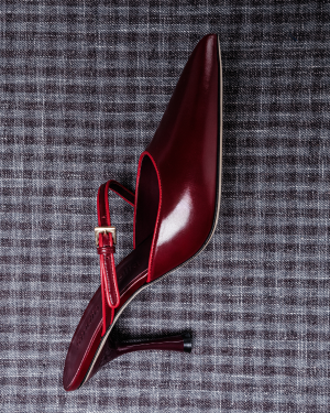 Red high-heeled shoe on a textured gray background