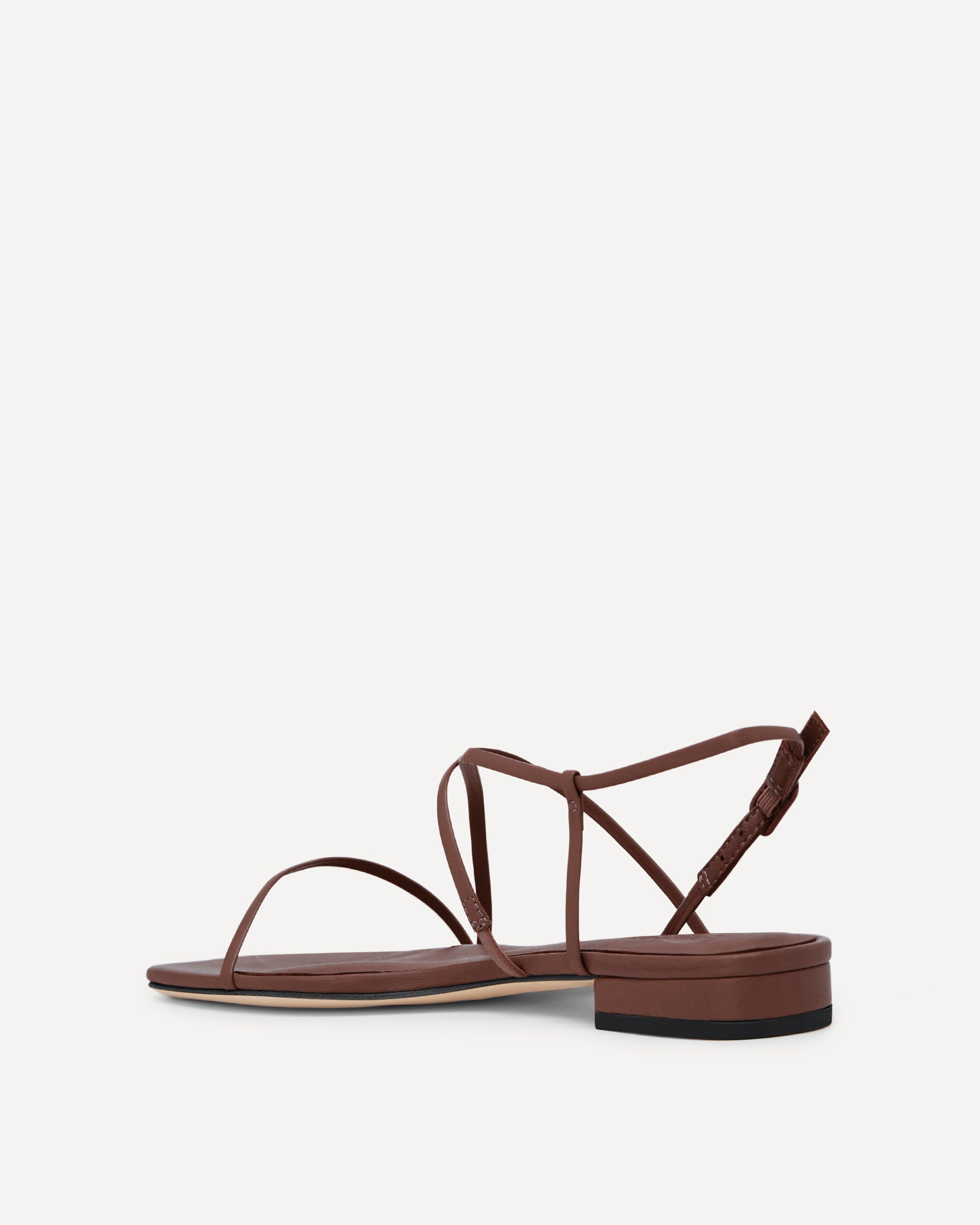 Brown sandal with thin straps on a white background