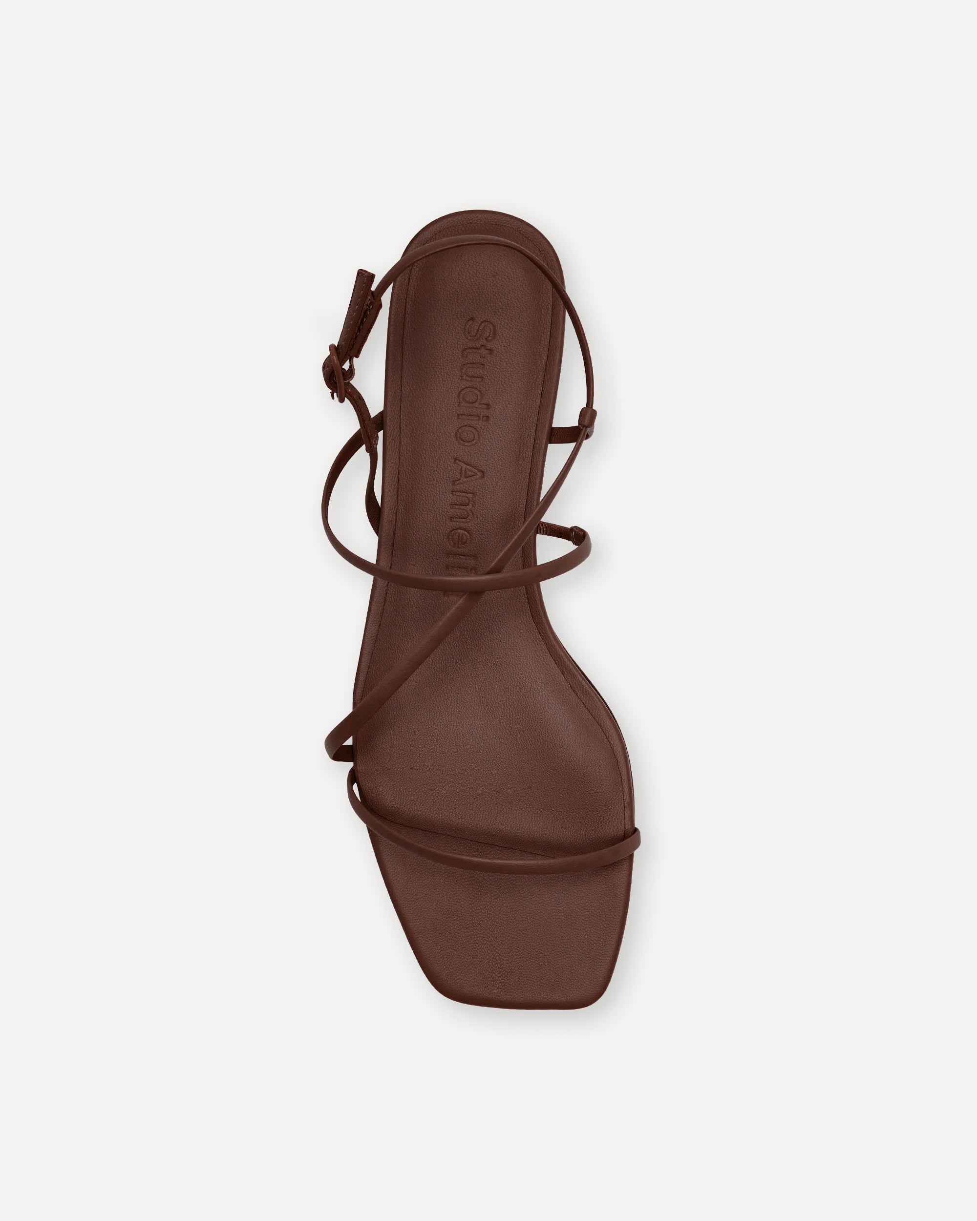 Brown sandal with strappy design on a white background