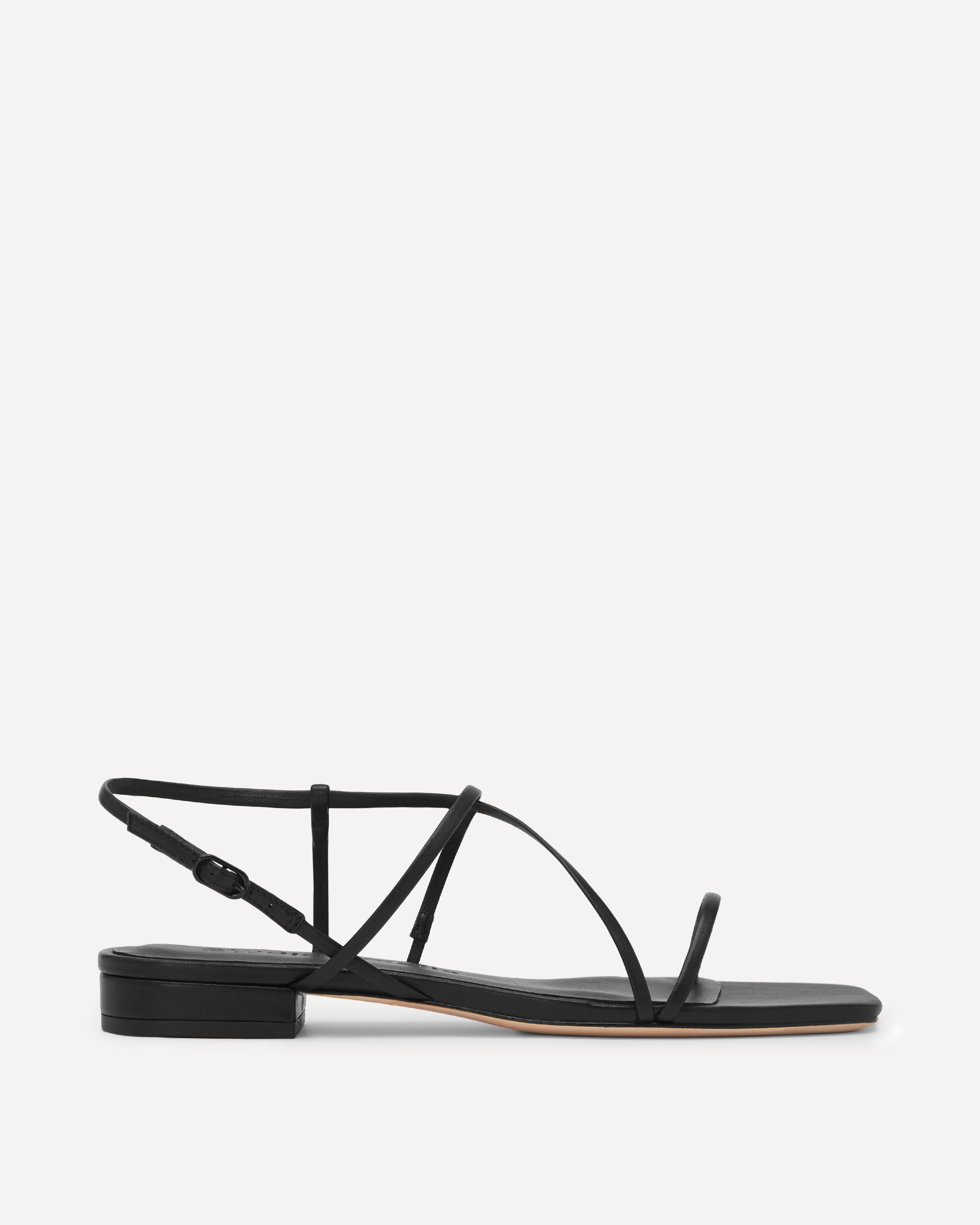Black sandal with thin straps on a white background