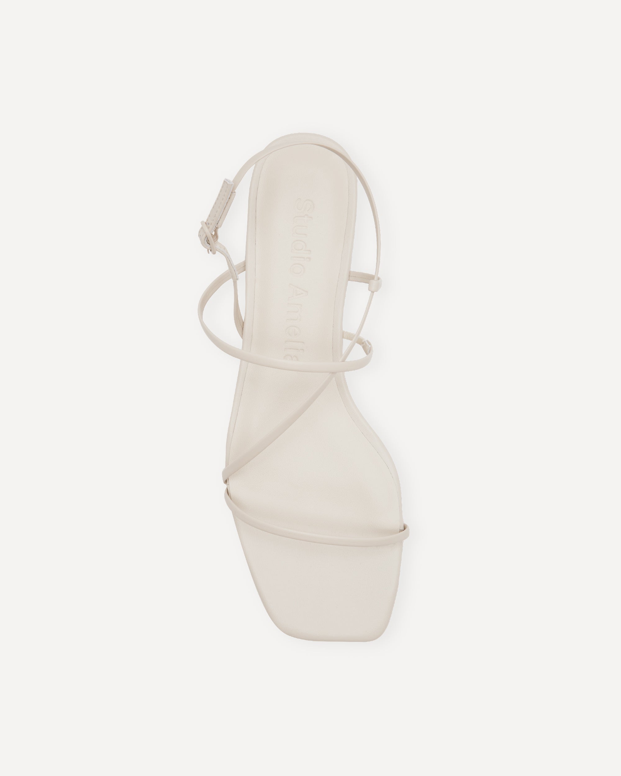 White sandal with a strap on a white background