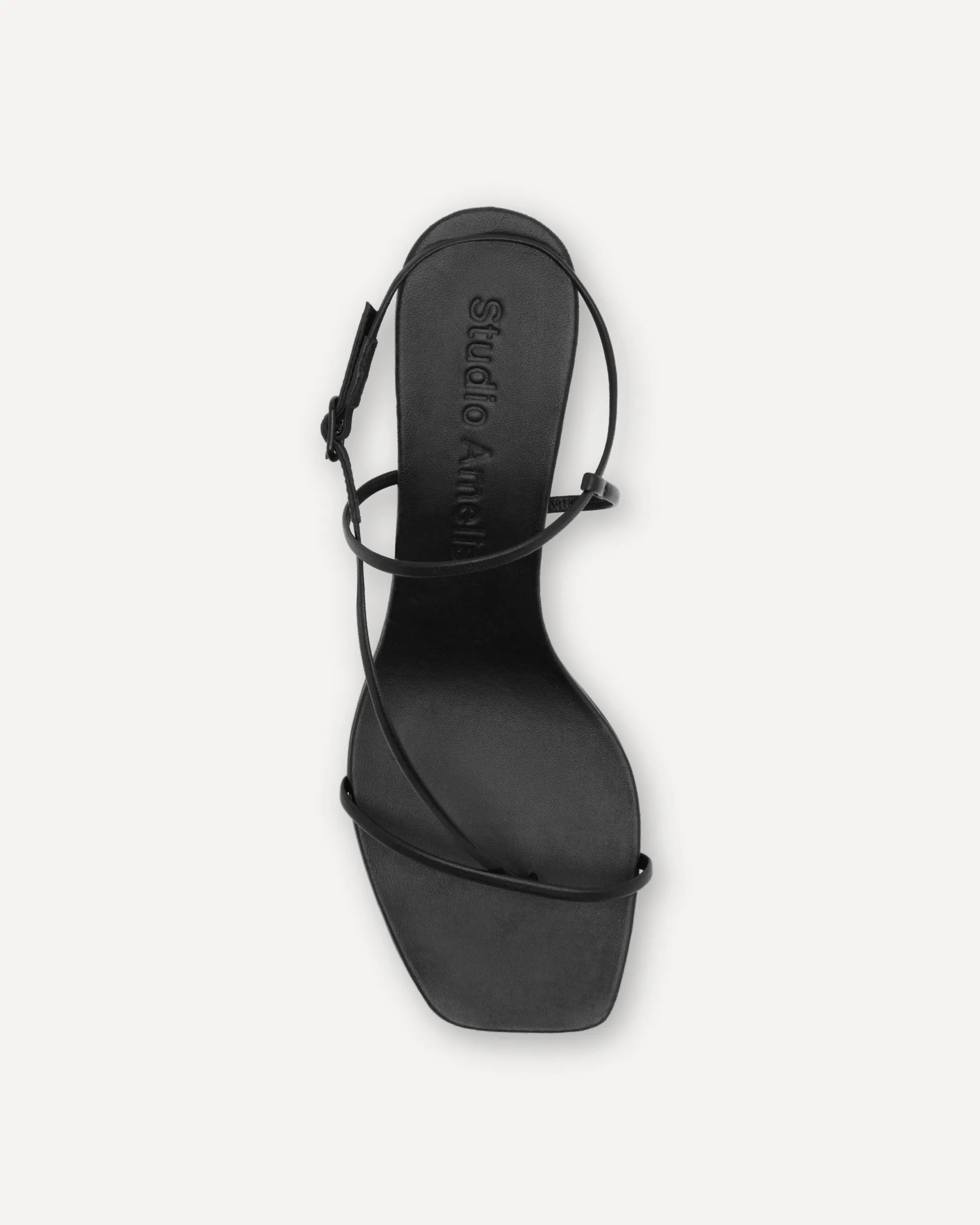 Black sandal with thin straps on a white background