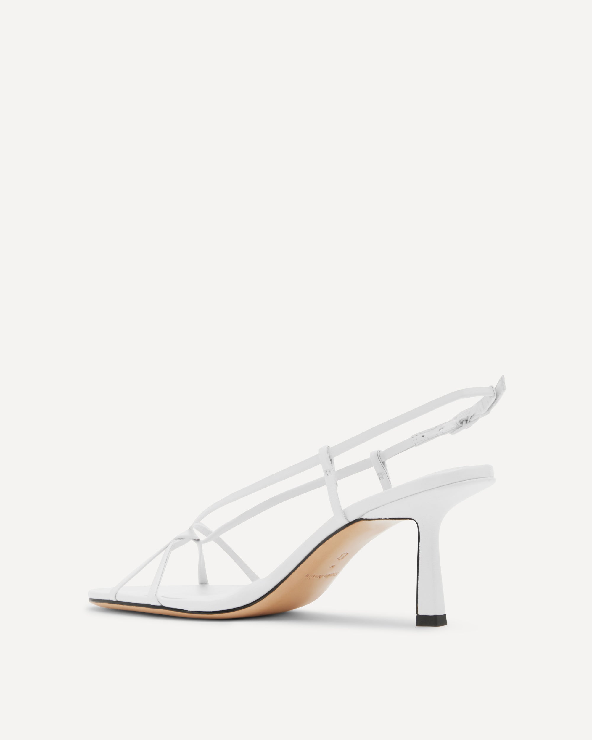 White sandal with thin straps on a white background
