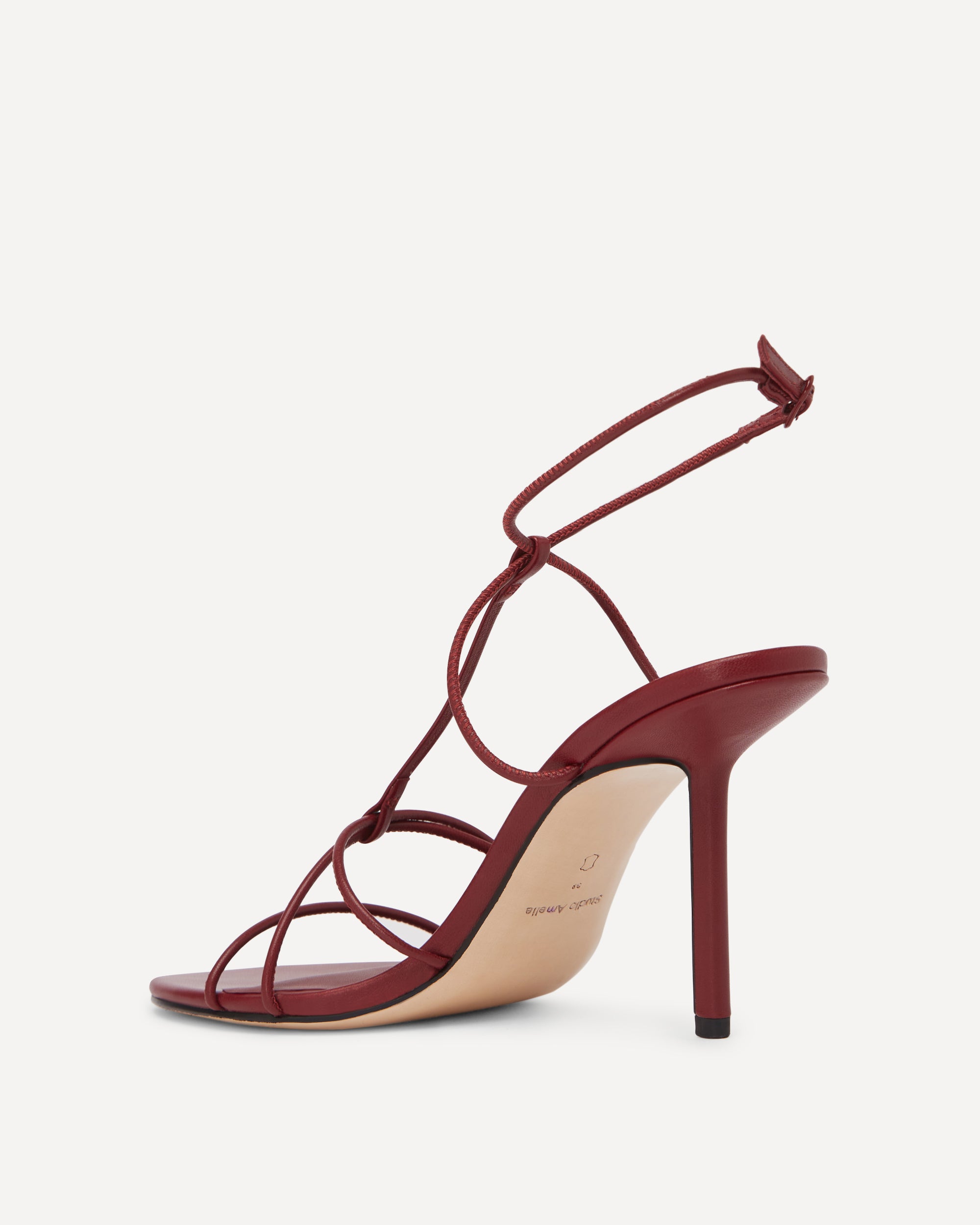 Red high-heeled sandal with strappy design on a white background