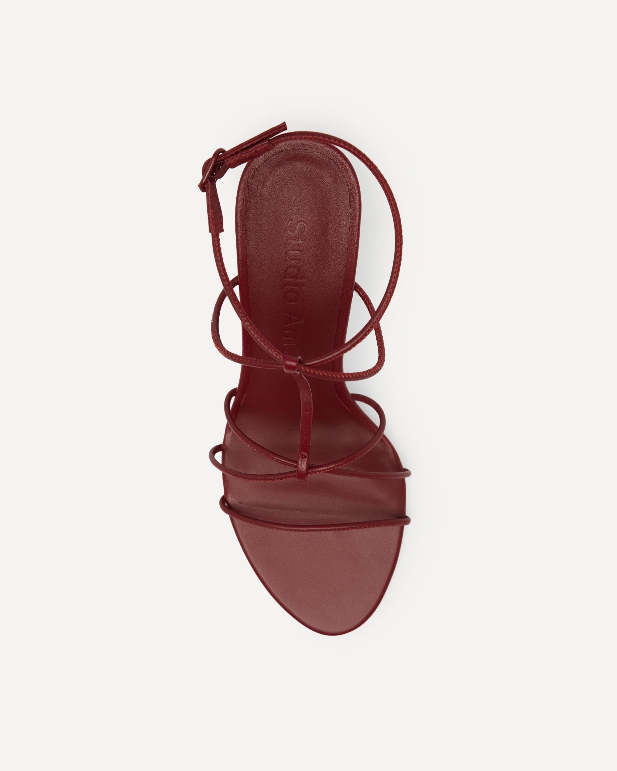 Red sandal with strappy design on a white background