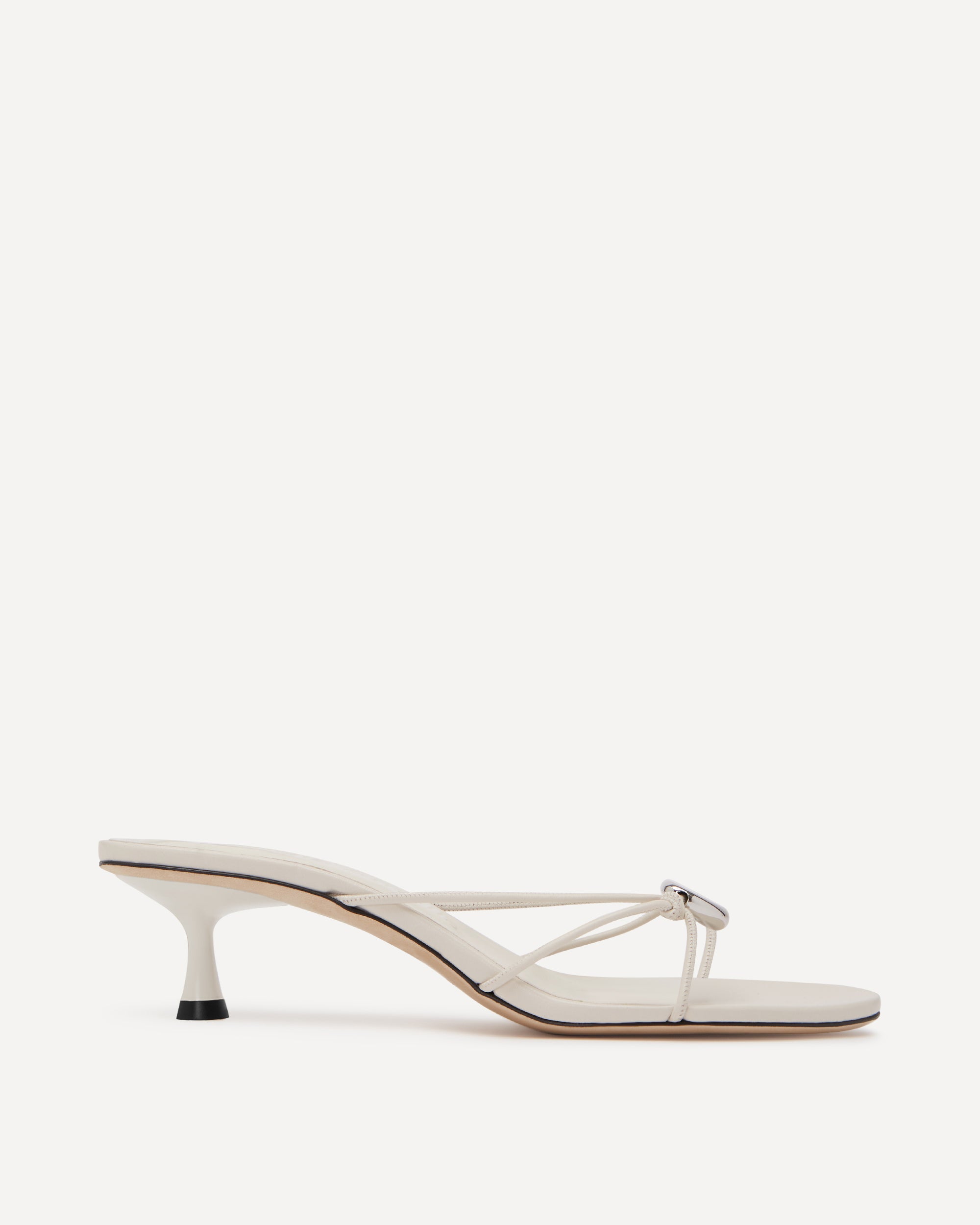White sandal with thin straps on a white background