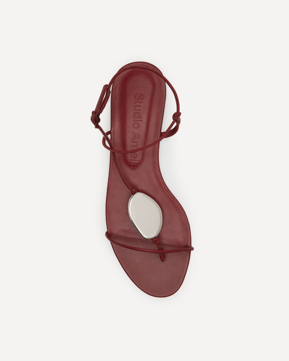 Red flat sandal with a silver pebble by Studio Amelia