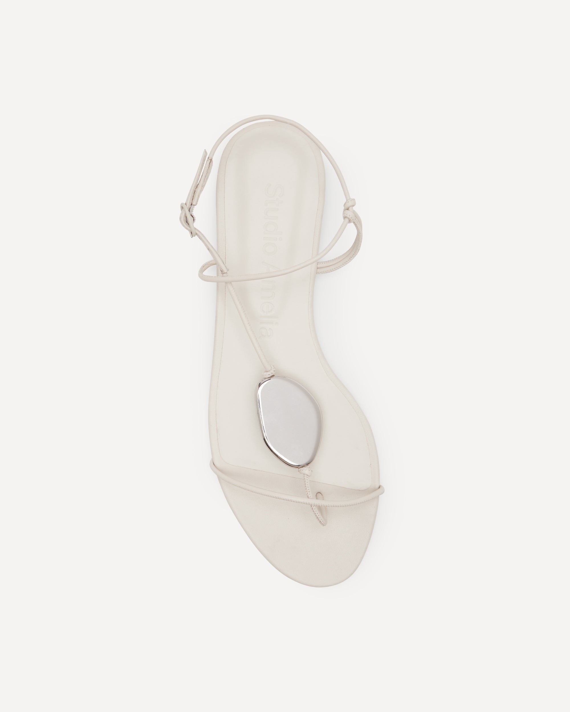 White flat sandal with straps on a white background