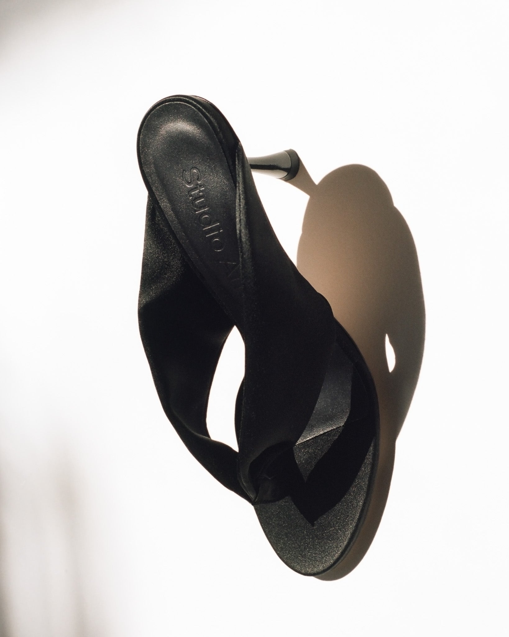 A black silk slipper with high heel