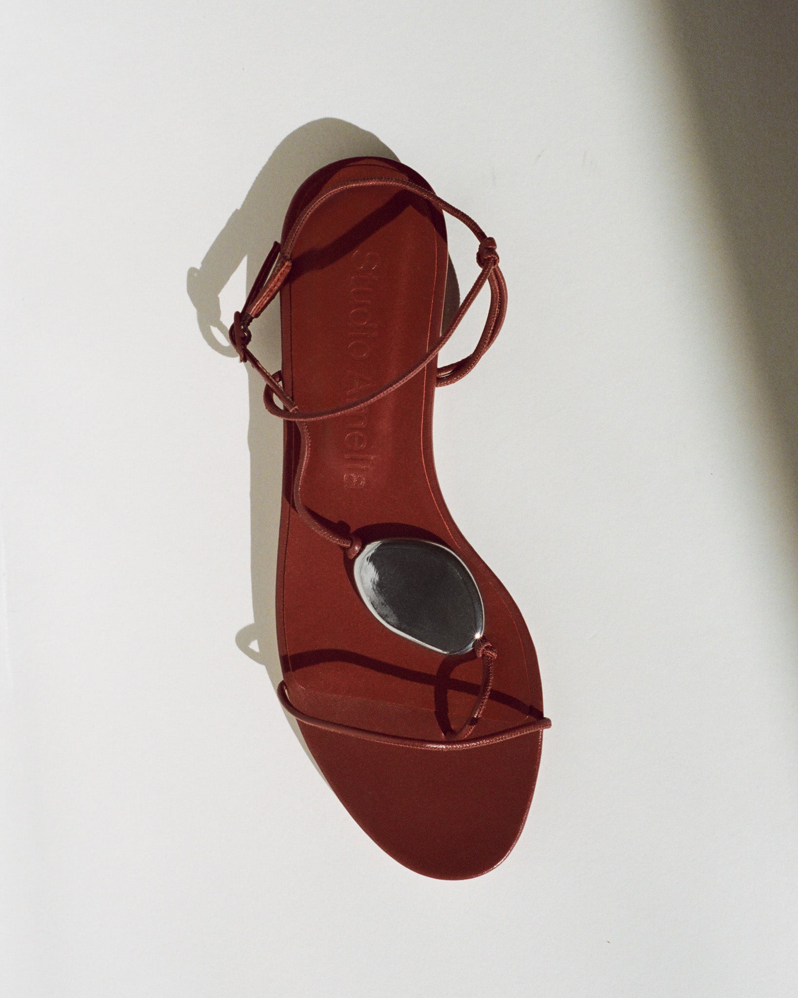 Red sandal with thin straps on a white background