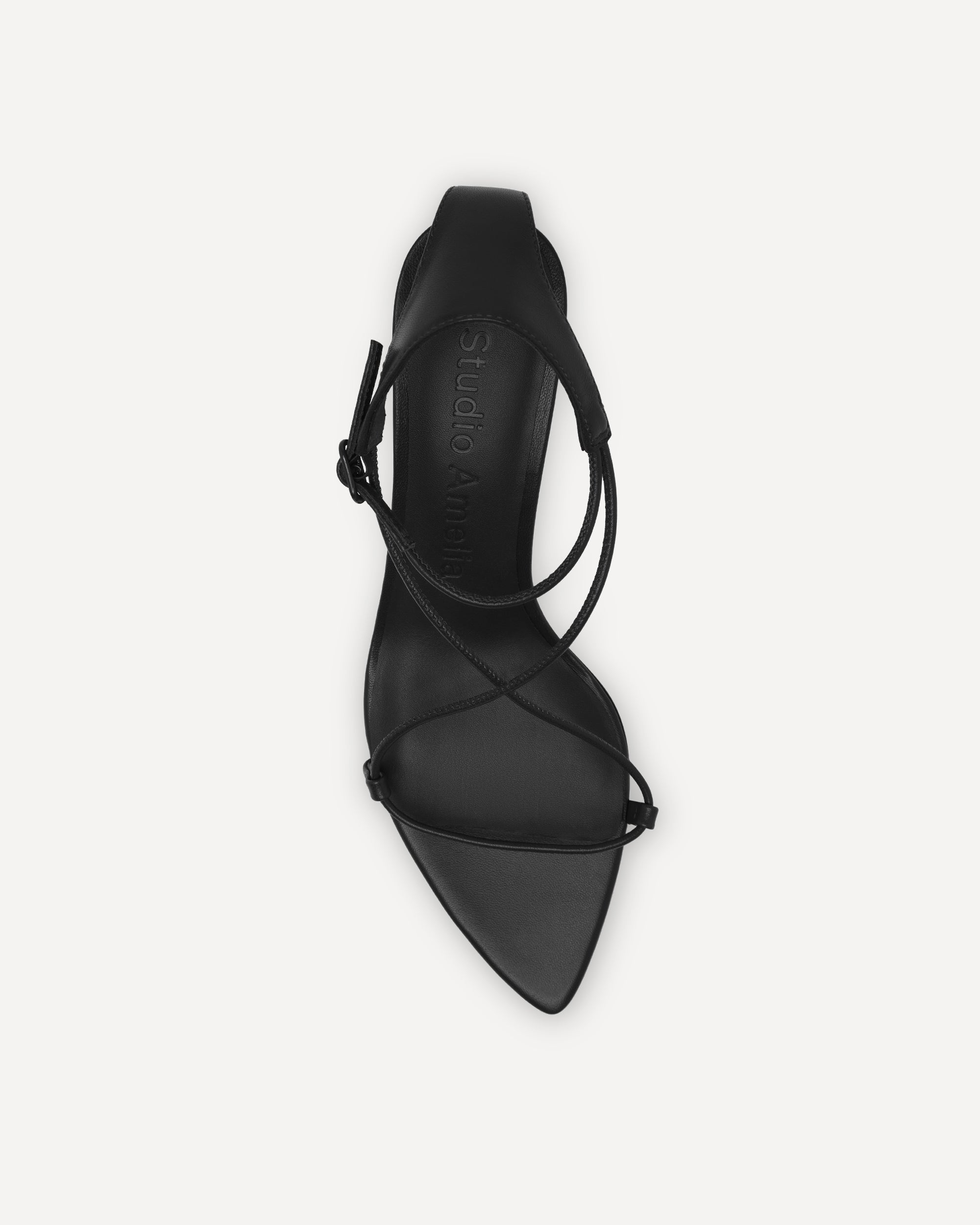 Black high-heeled shoe with ankle strap on a white background