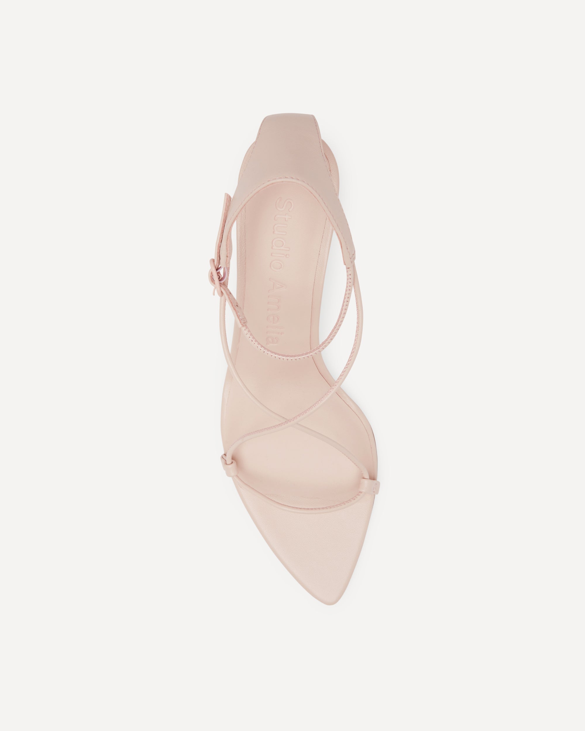 Pink high heel with cross straps on a white background