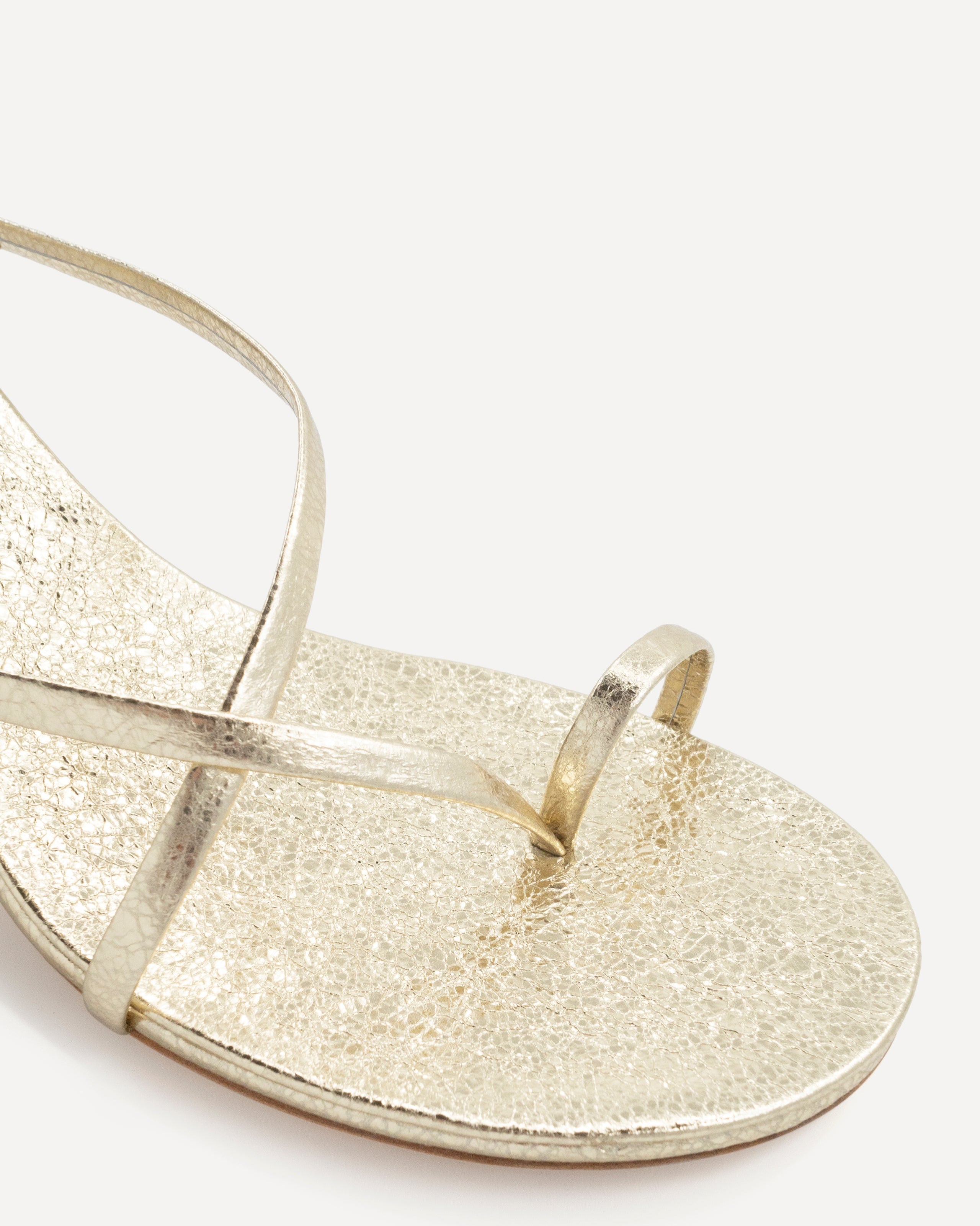 Toe strap on a gold leather high heel
