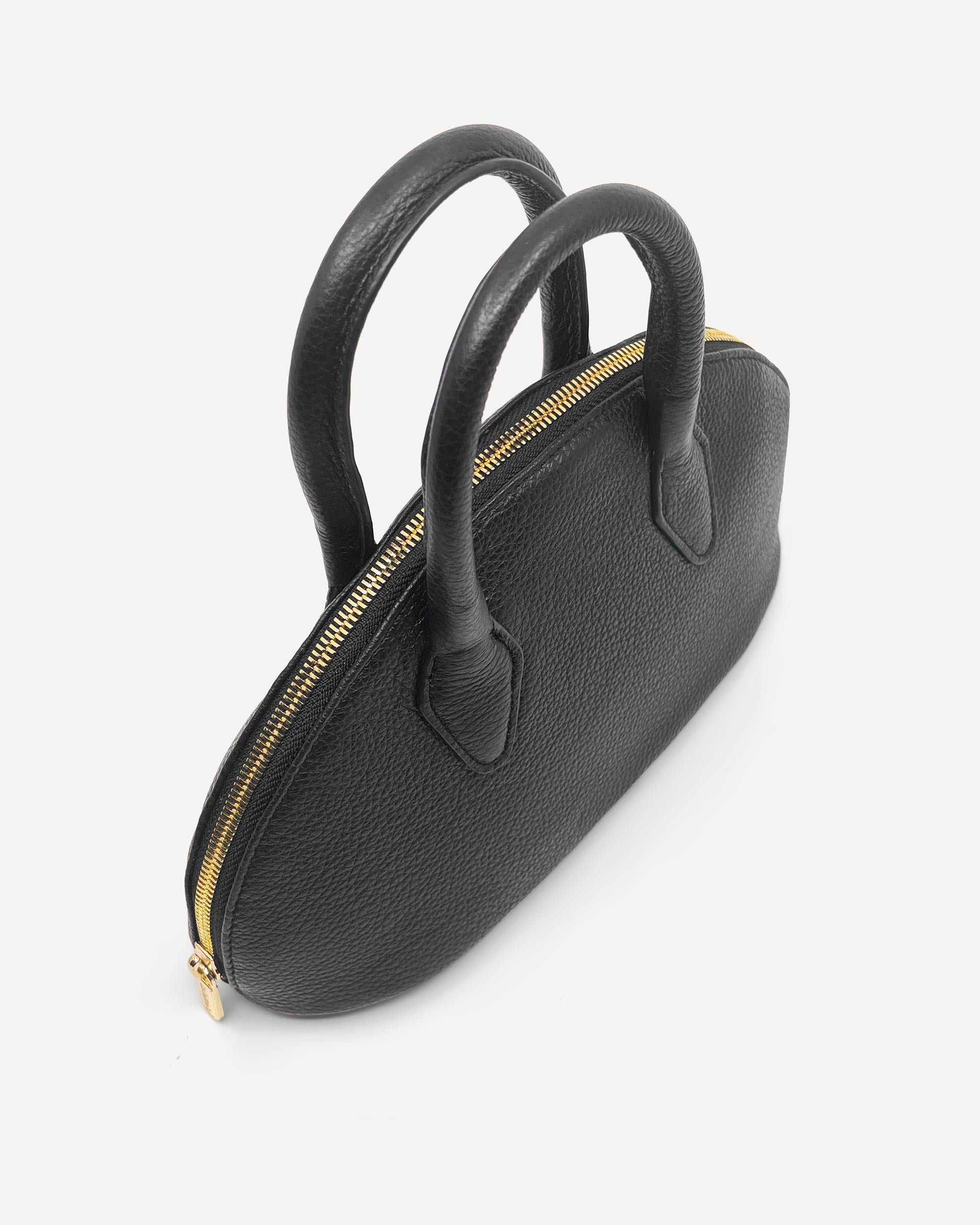 Black handbag with gold zipper on a white background