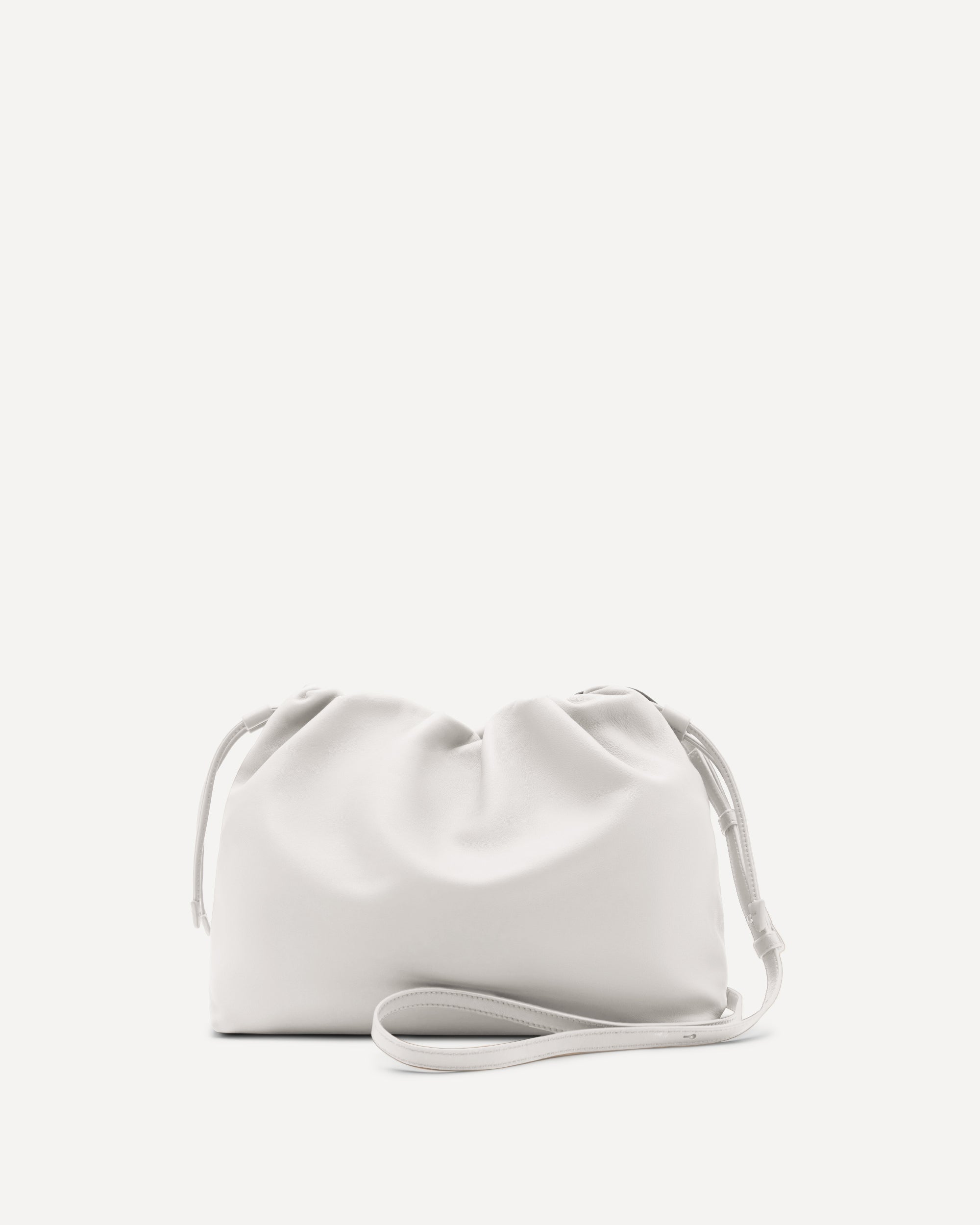 White handbag with a strap on a light beige background