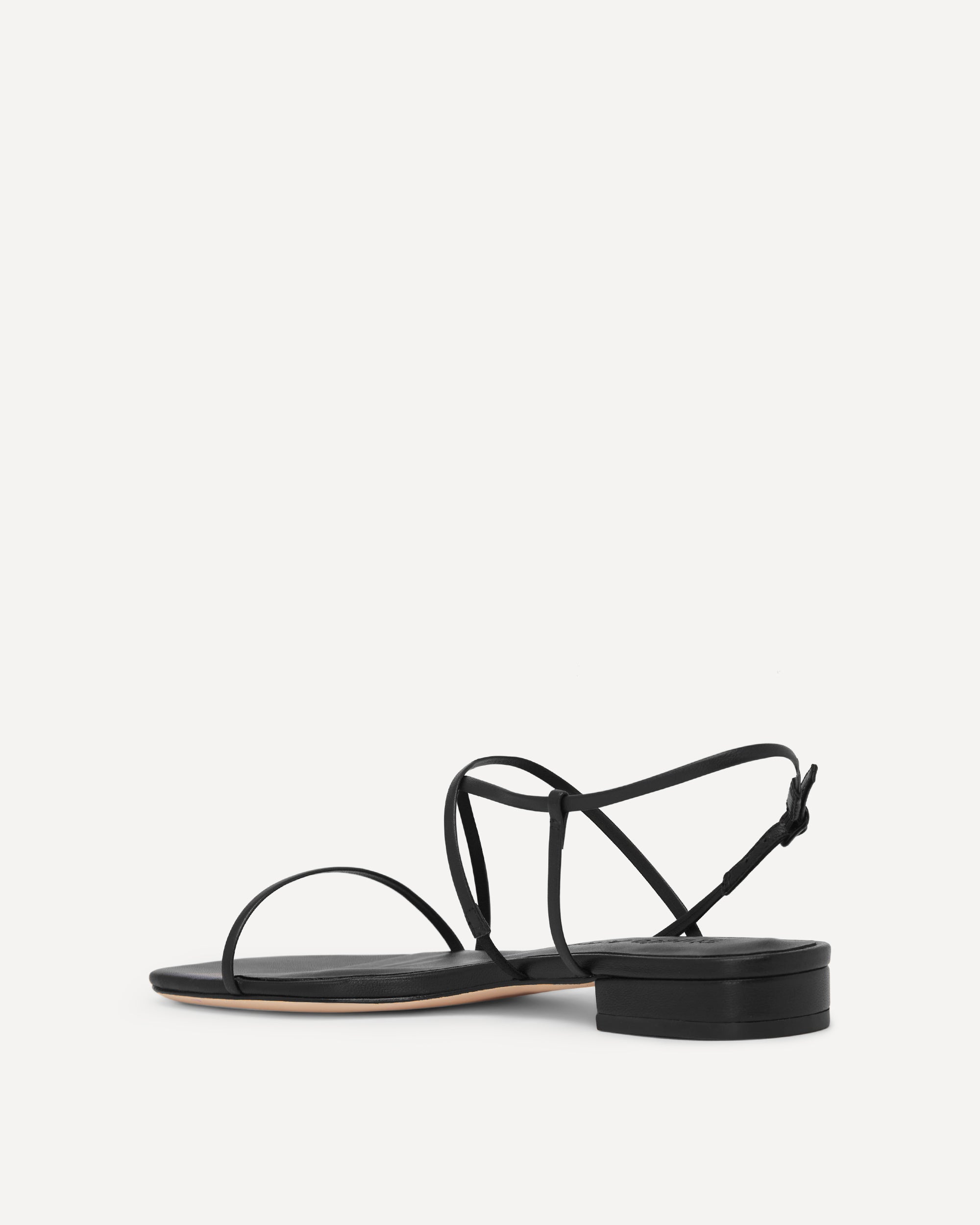Black sandal with thin straps on a white background