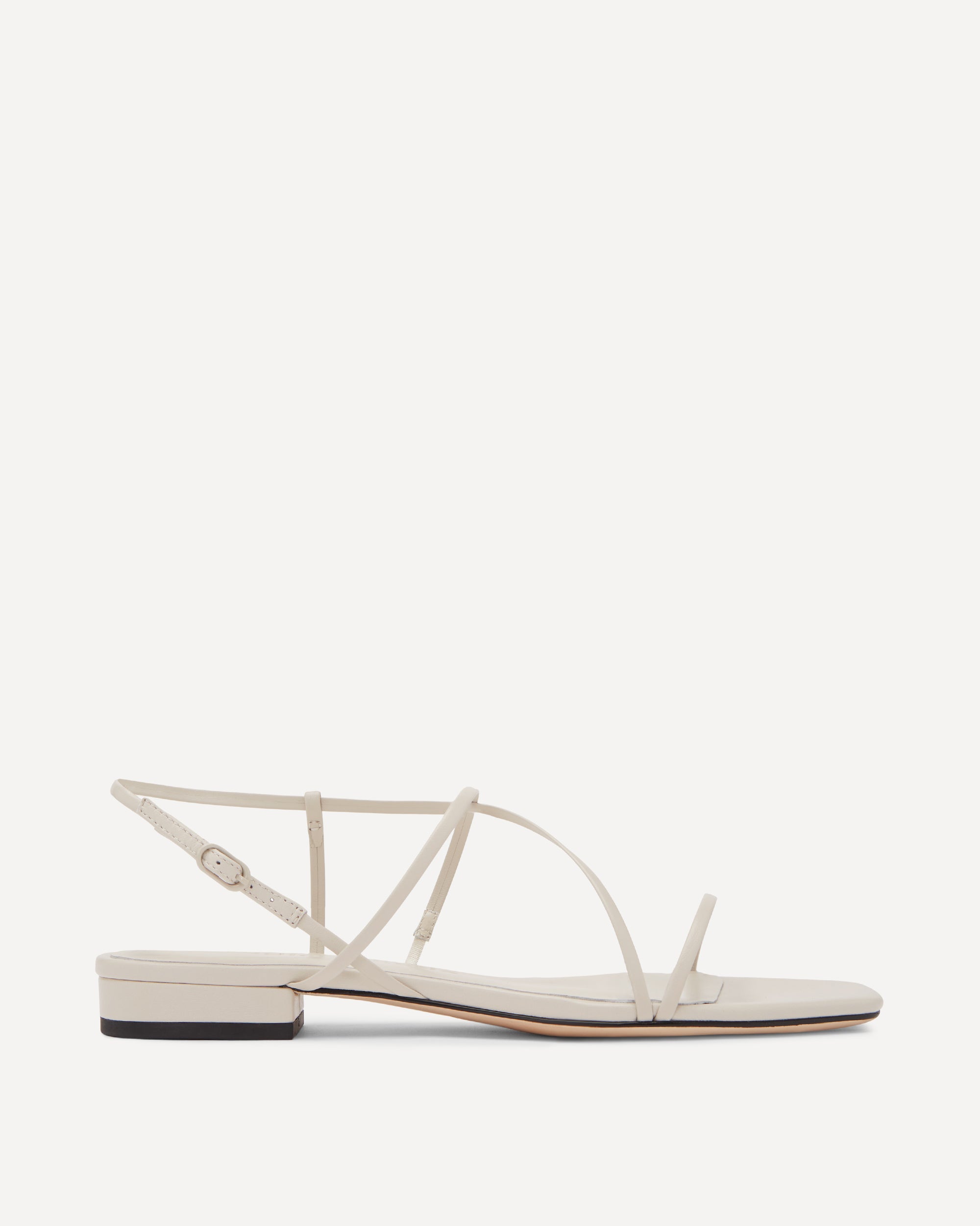 White sandal with thin straps on a white background