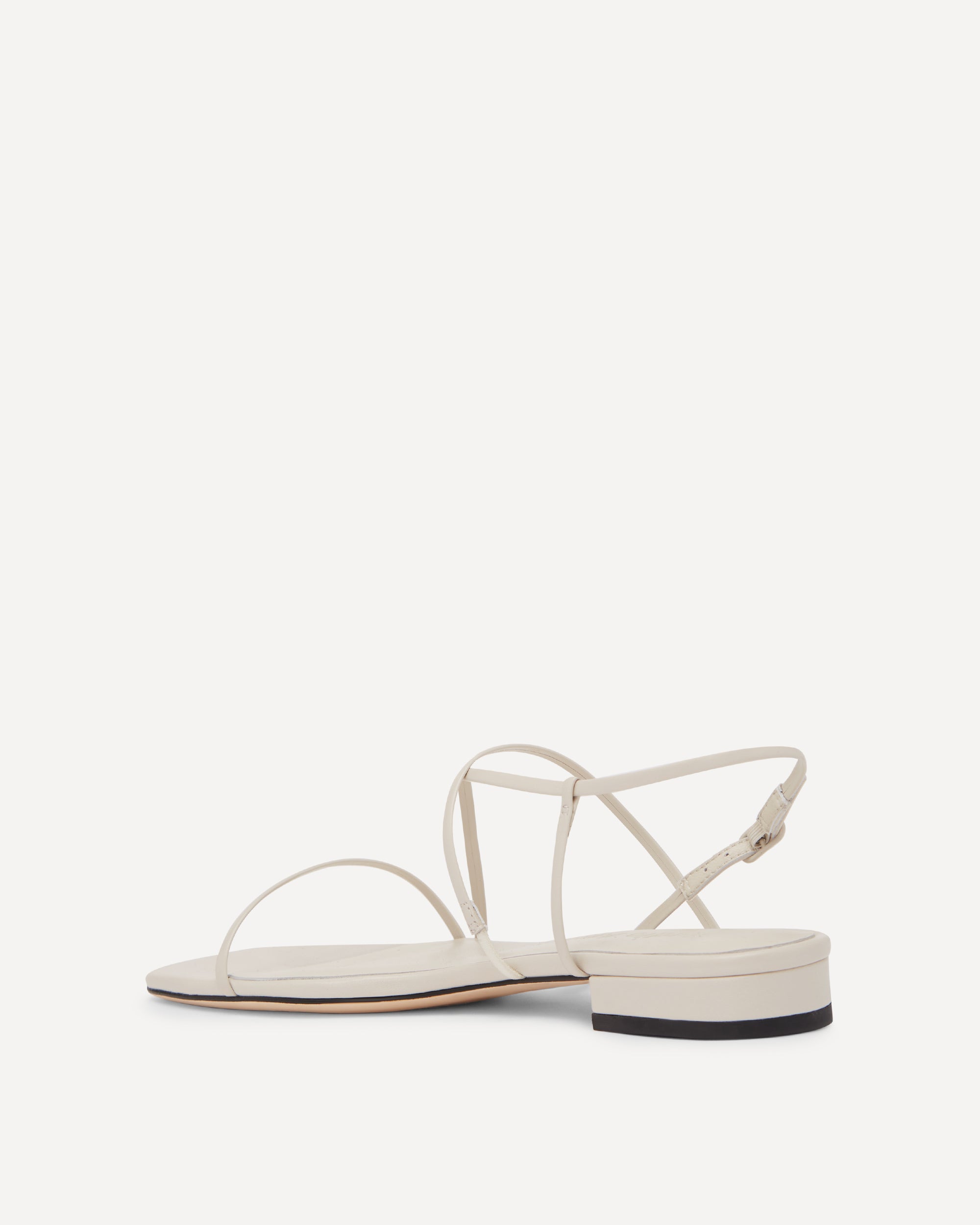 White sandal with adjustable thin straps on a white background