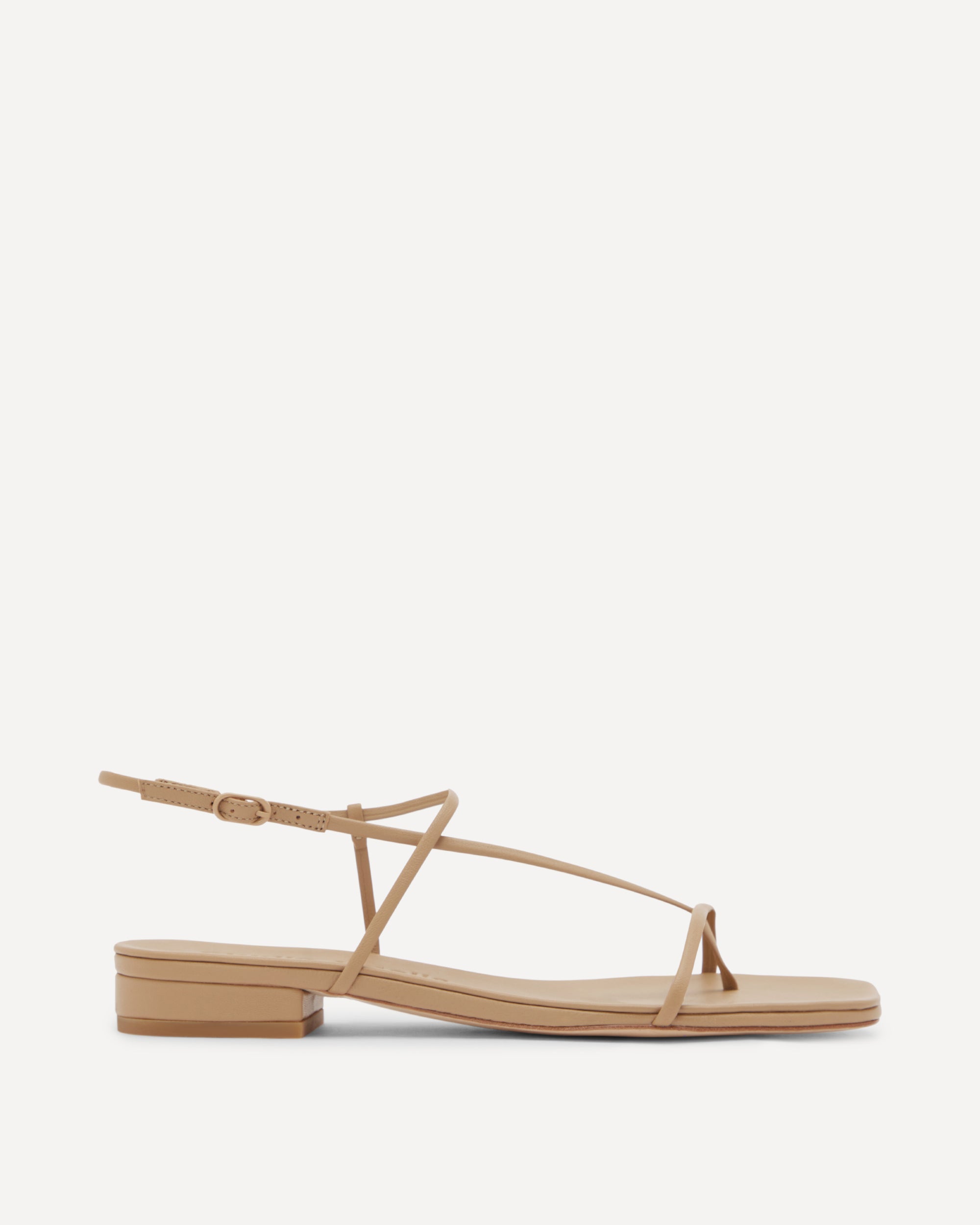 Beige flat sandal with thin straps on a white background