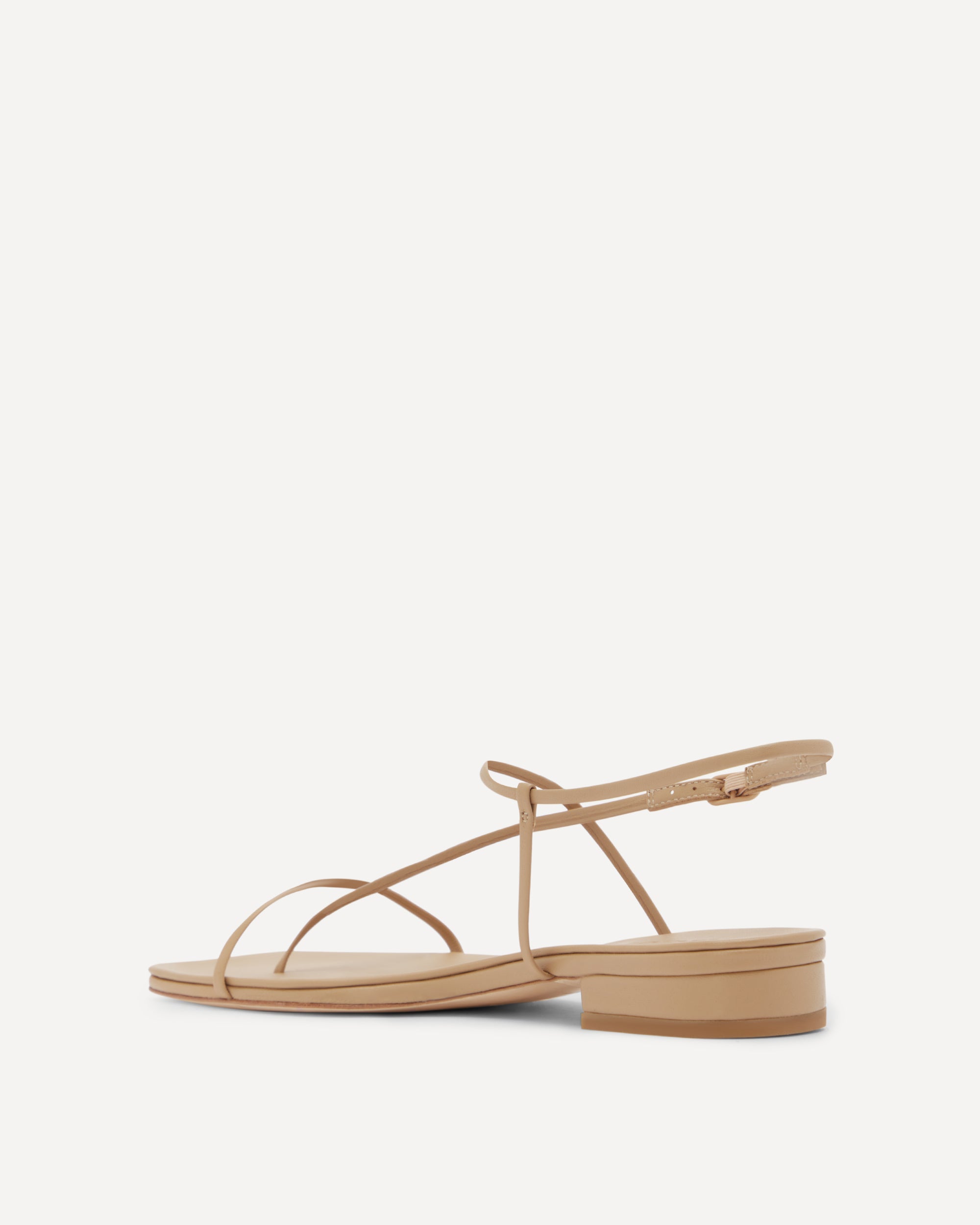 Beige flat sandal with thin straps on a white background