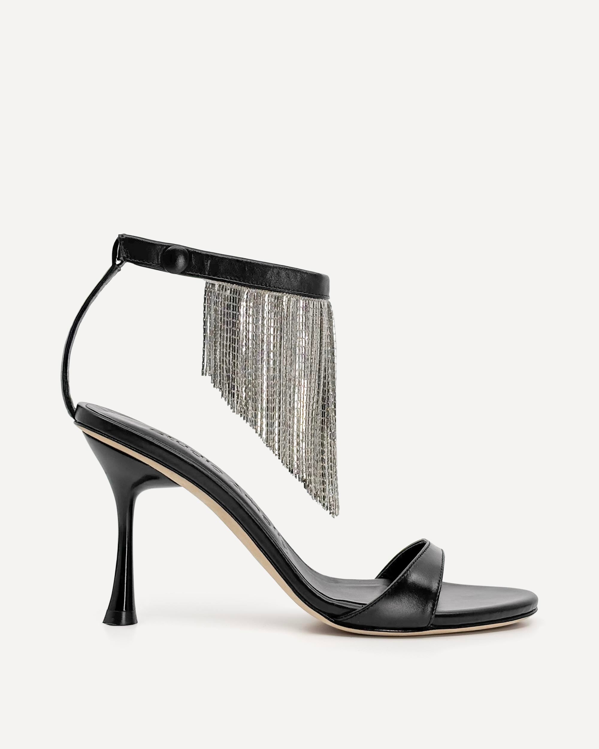 Black high-heeled sandal with silver fringe on a white background