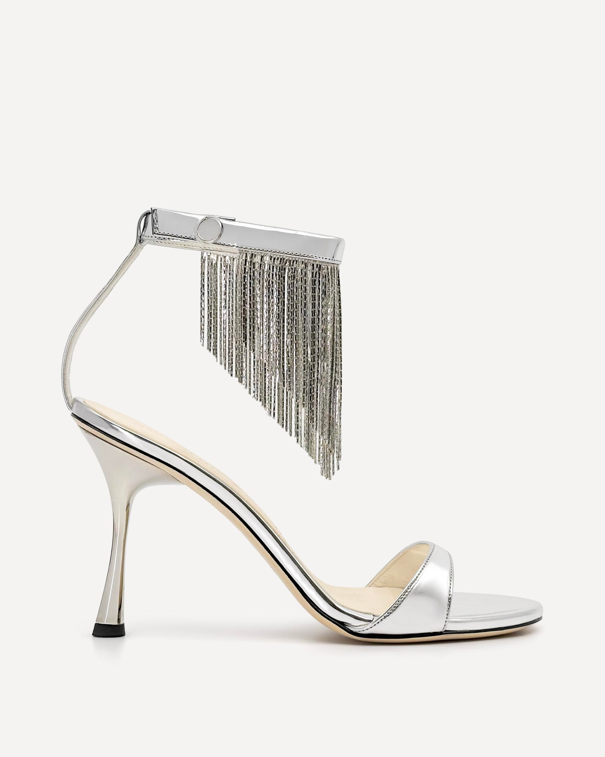 Silver high-heeled sandal with fringe detail on a white background