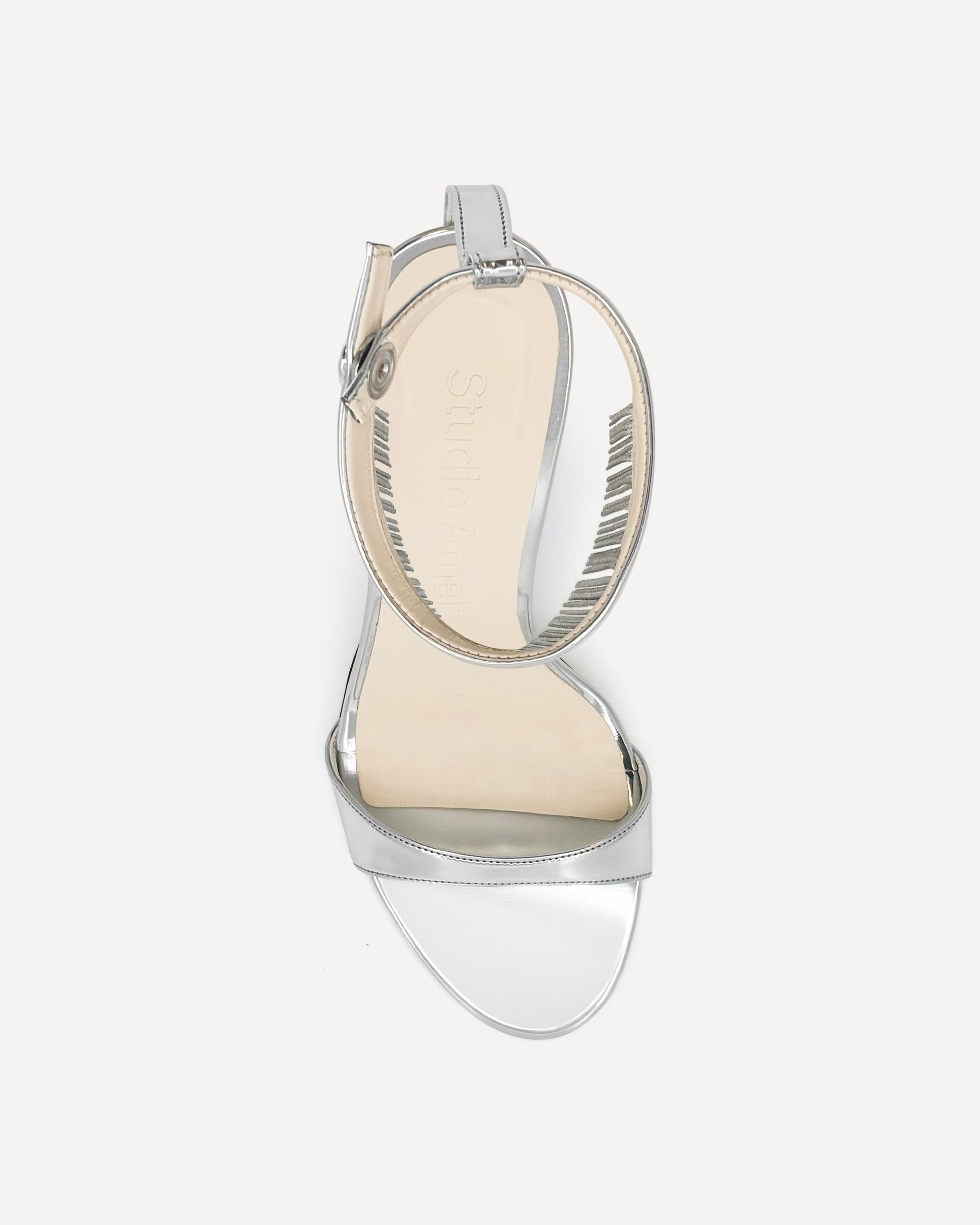 Silver high-heeled sandal with clear heel on a white background