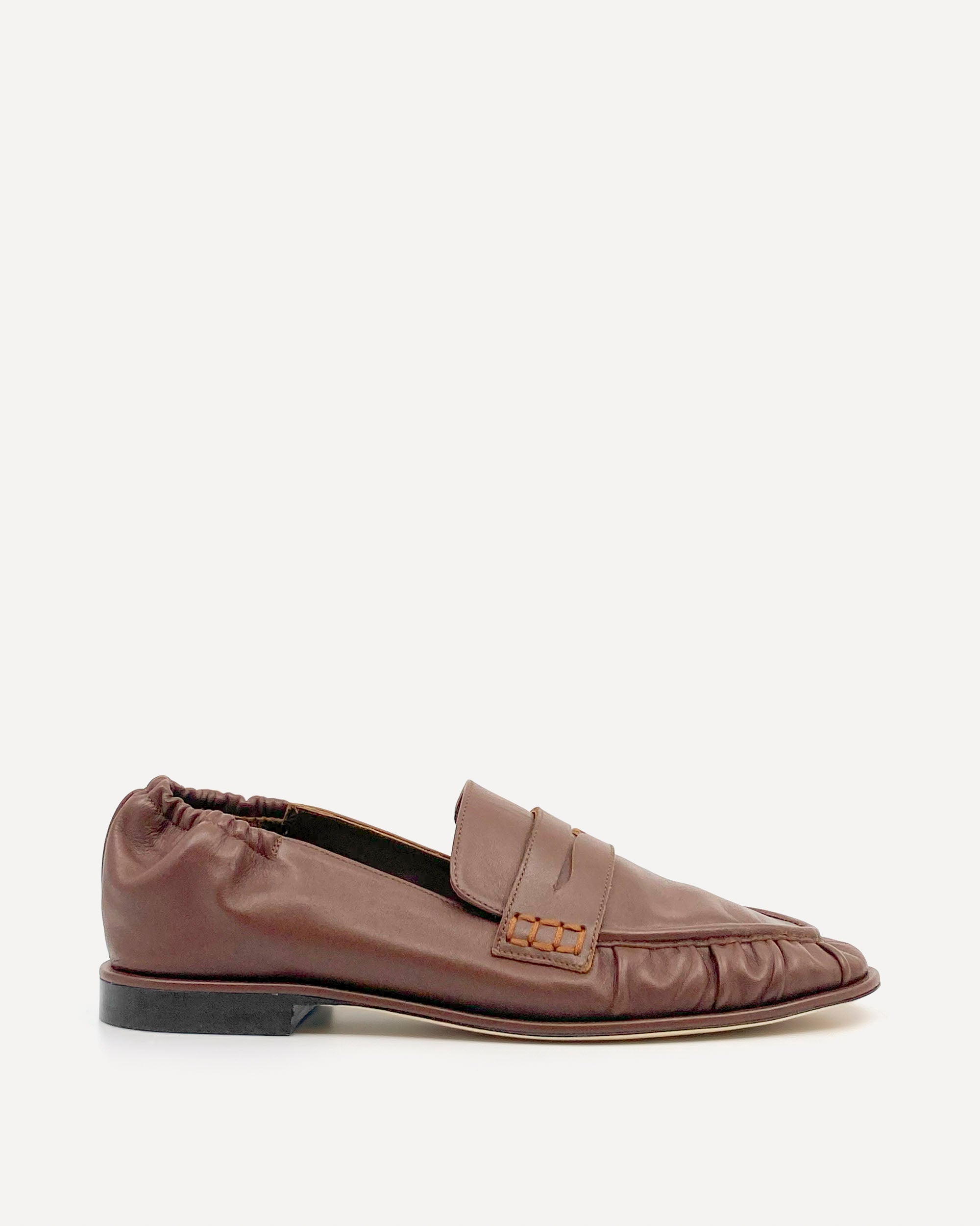 Brown leather loafers on a white background