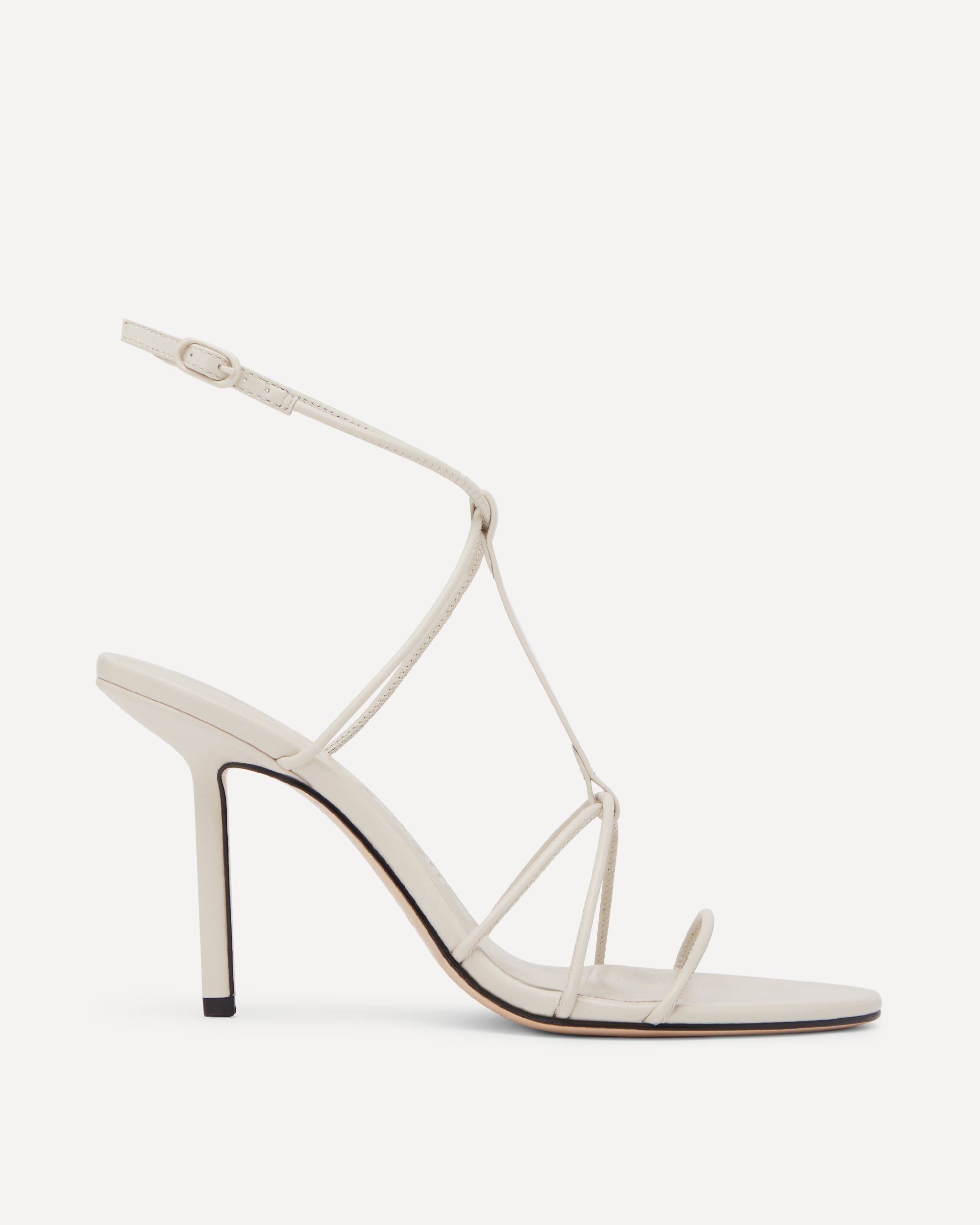 A white strappy high heel with thin straps