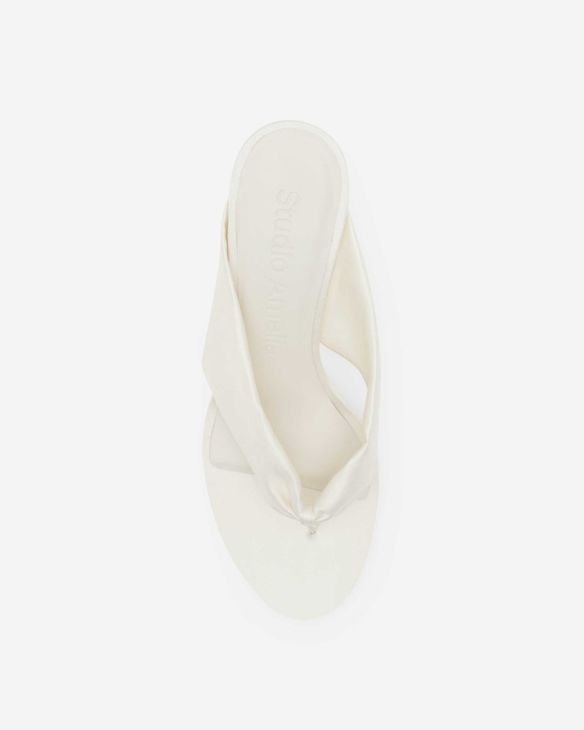 White silk sandal with a thin heel on a white background