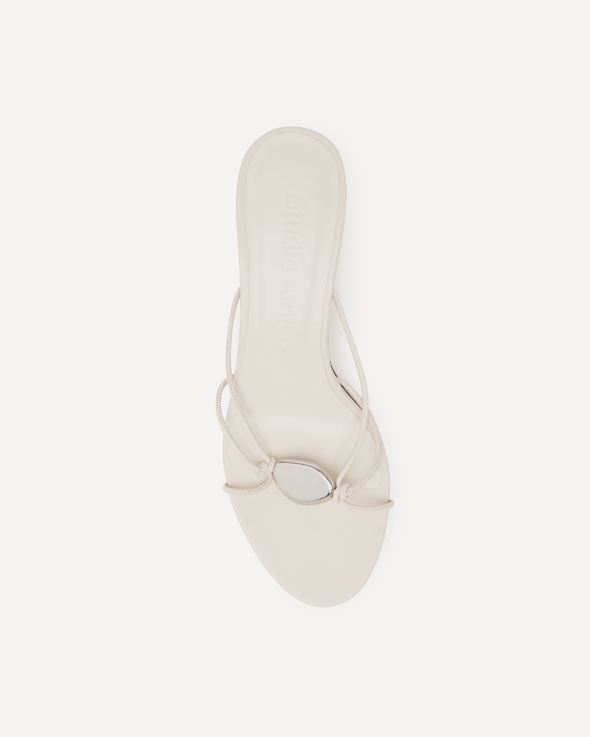 White sandal with silver pebble on a white background