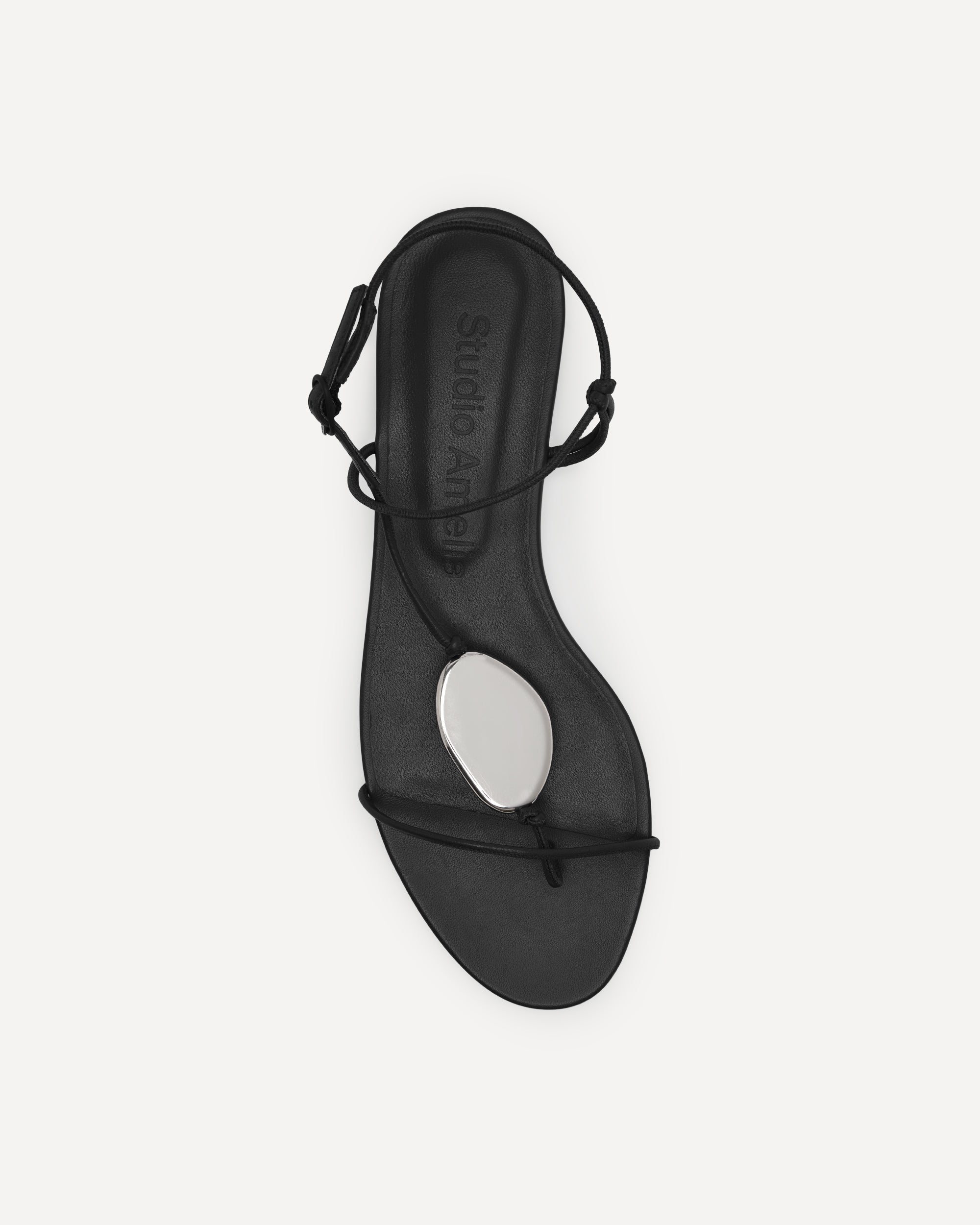 Black sandal with thin straps on a white background