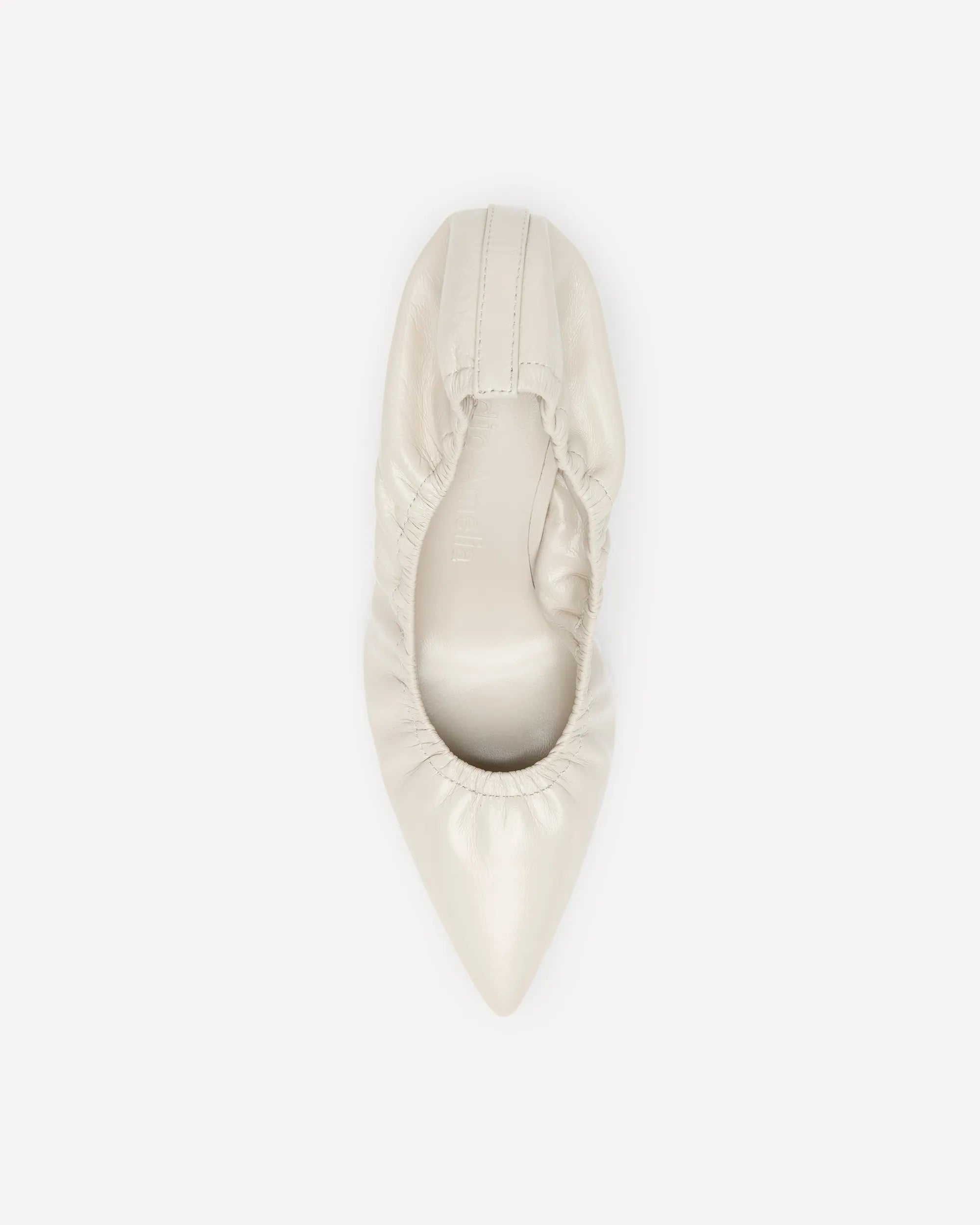 A cream coloured leather heel with a pointed toe