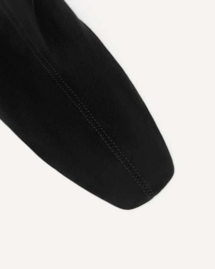 Close-up of a black suede boot with a soft square toe