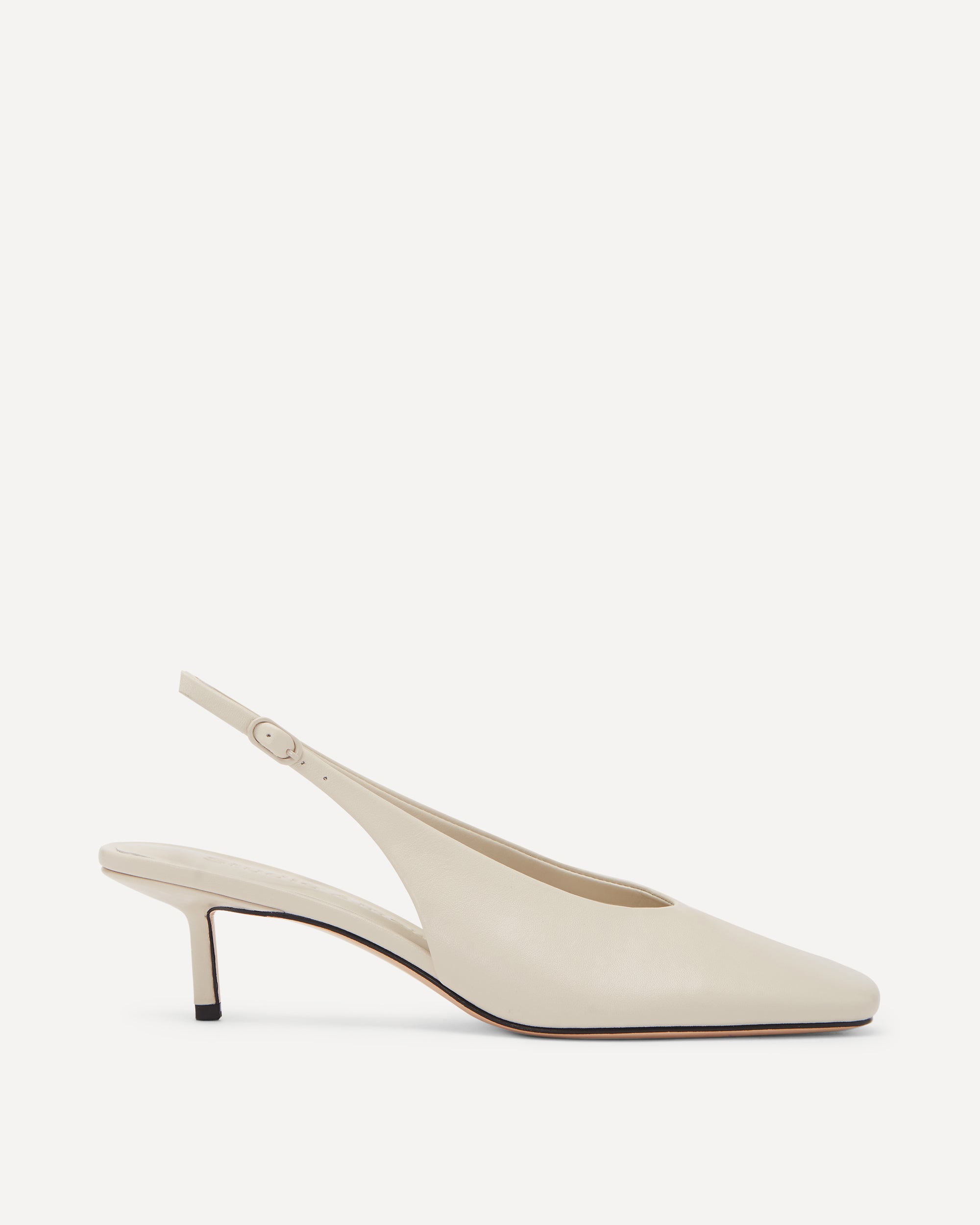 A cream coloured leather pump with a kitten heel