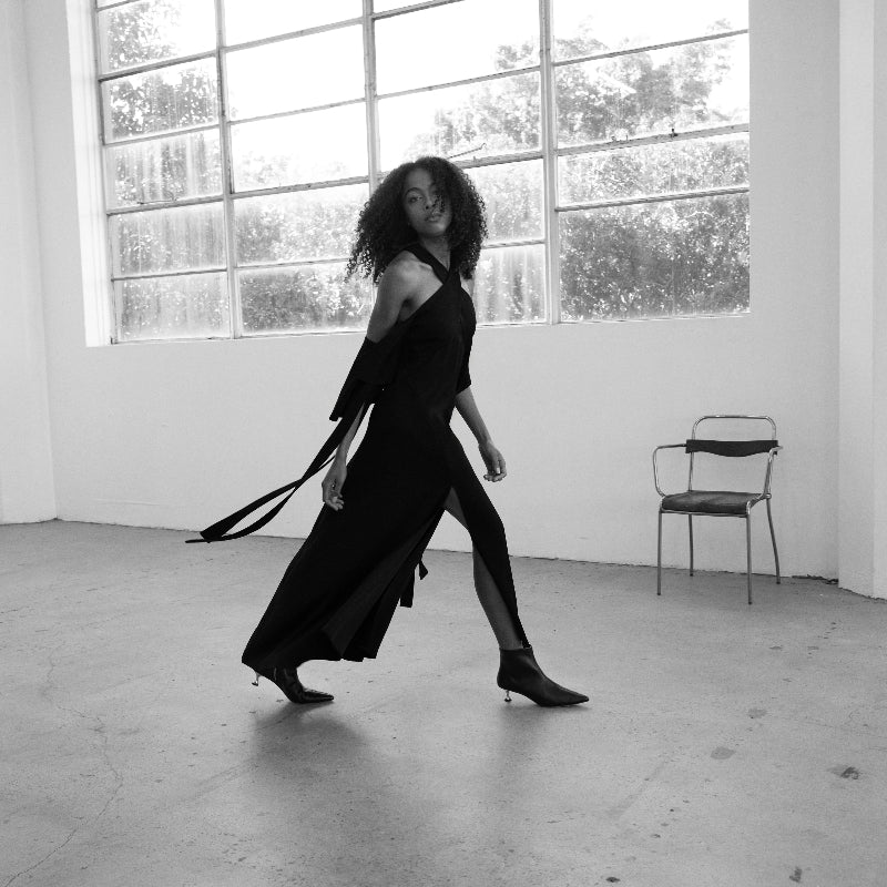 A woman wearing a pair of black leather boots with kitten heels