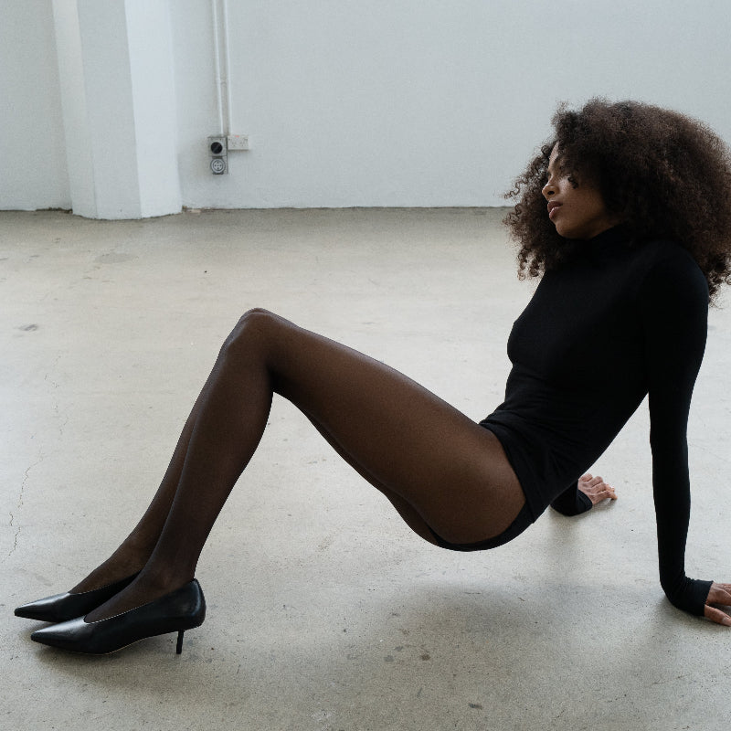 A woman wearing black leather kitten heels