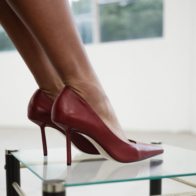 Red high-heeled shoes on a glass table with a blurred background