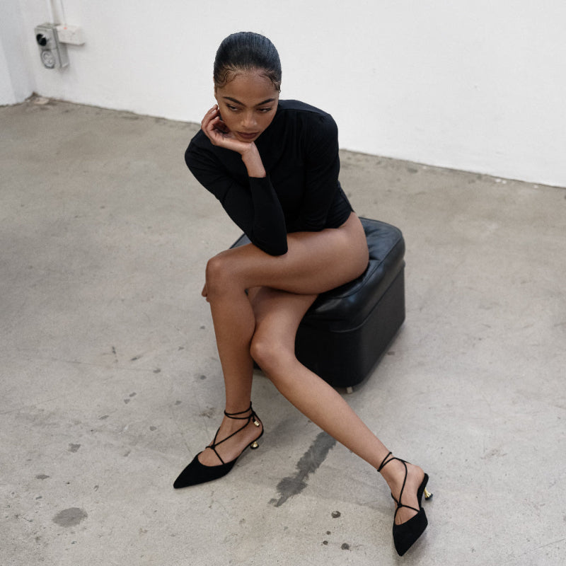 A woman wearing black kitten heels