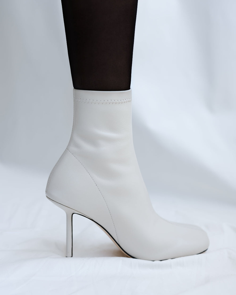 White leather ankle boots with high heels