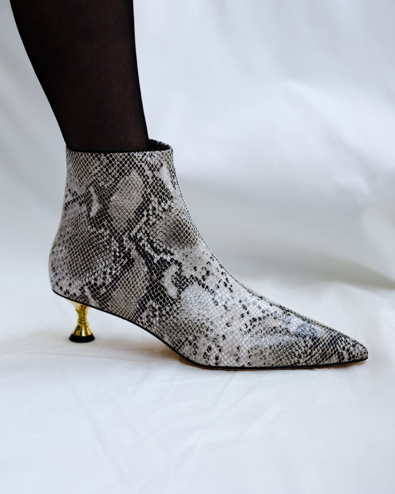 A snake-skinned leather boot with gold kitten heel