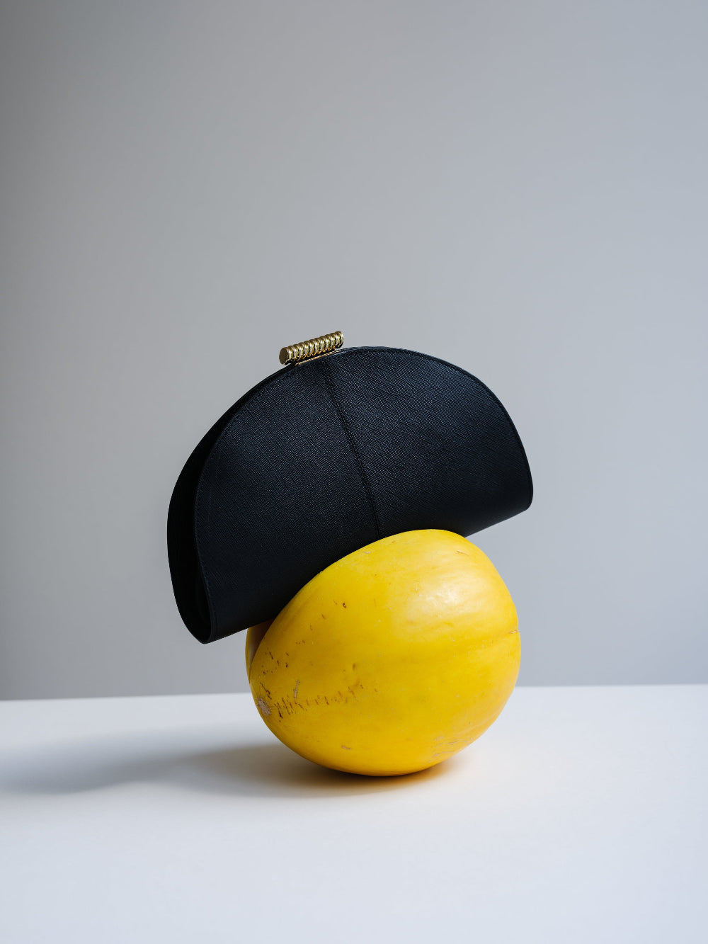 Black hat on a yellow fruit against a gray background