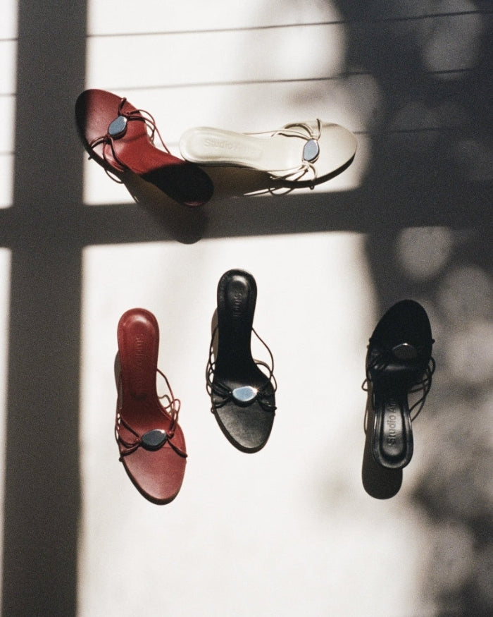 Pairs of flat sandals with straps by Studio Amelia