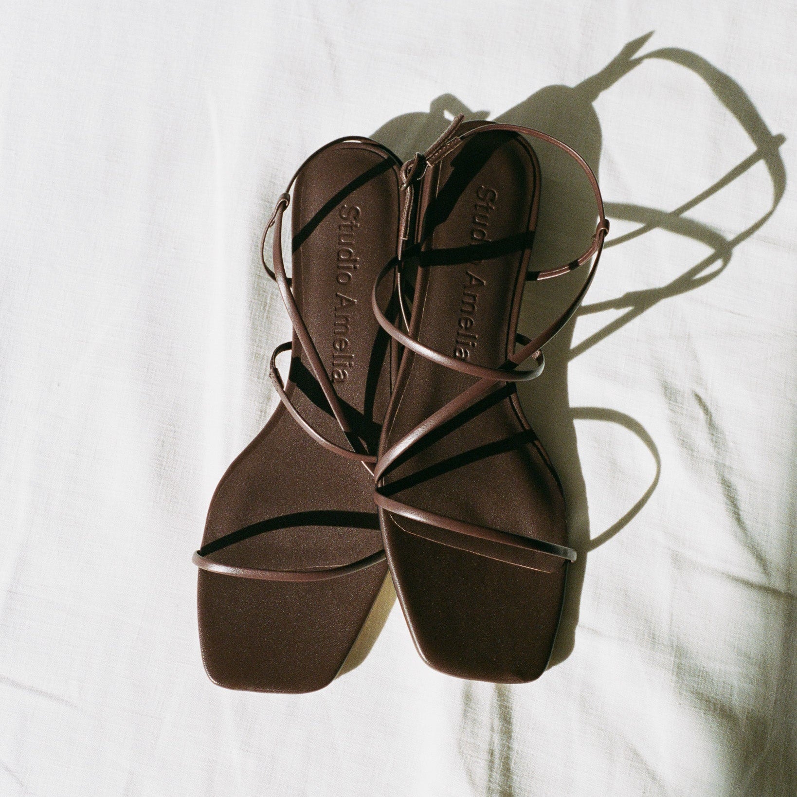 A brown chocolate strappy flat shoe by Studio Amelia