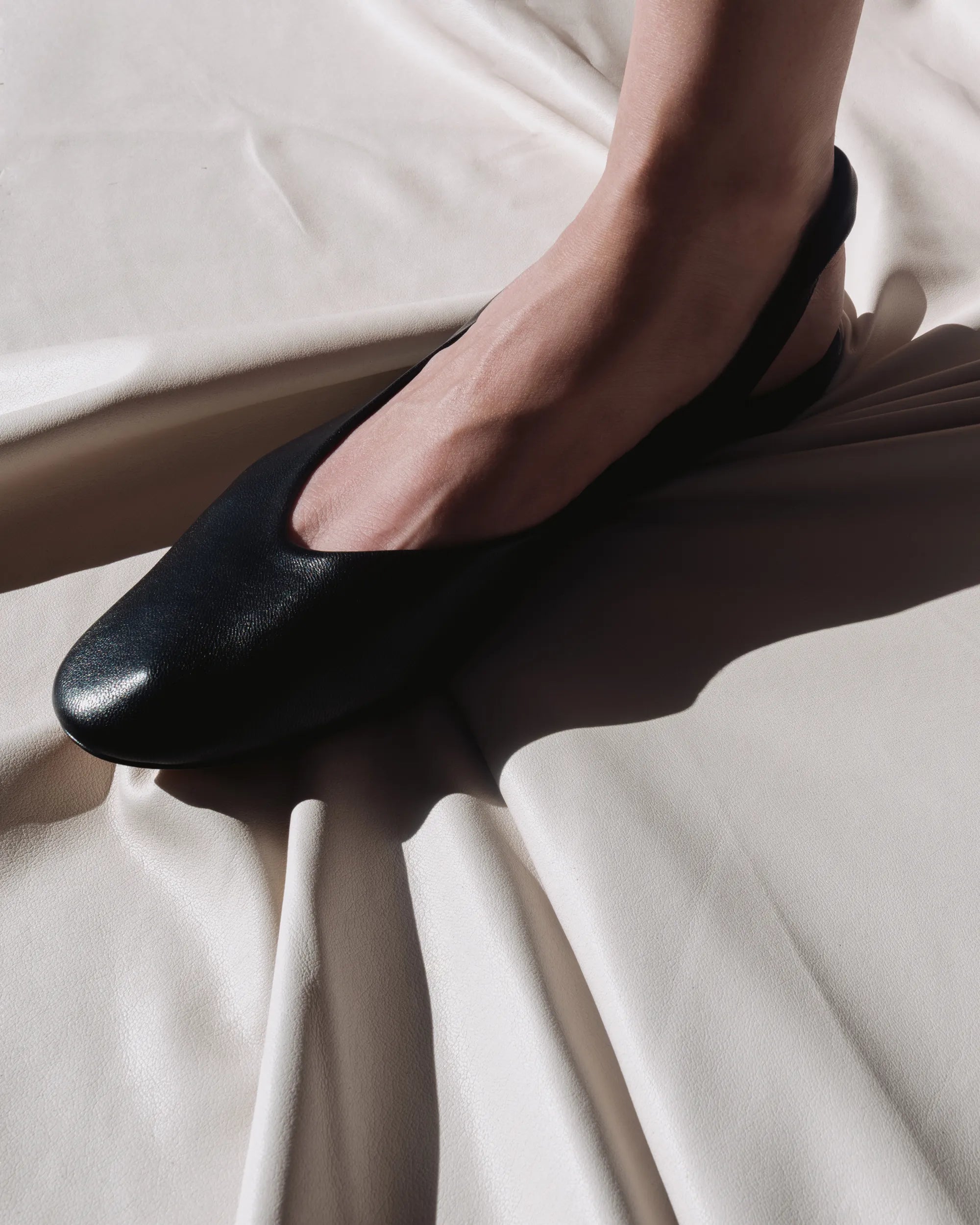 Black leather flat shoes with a slingback