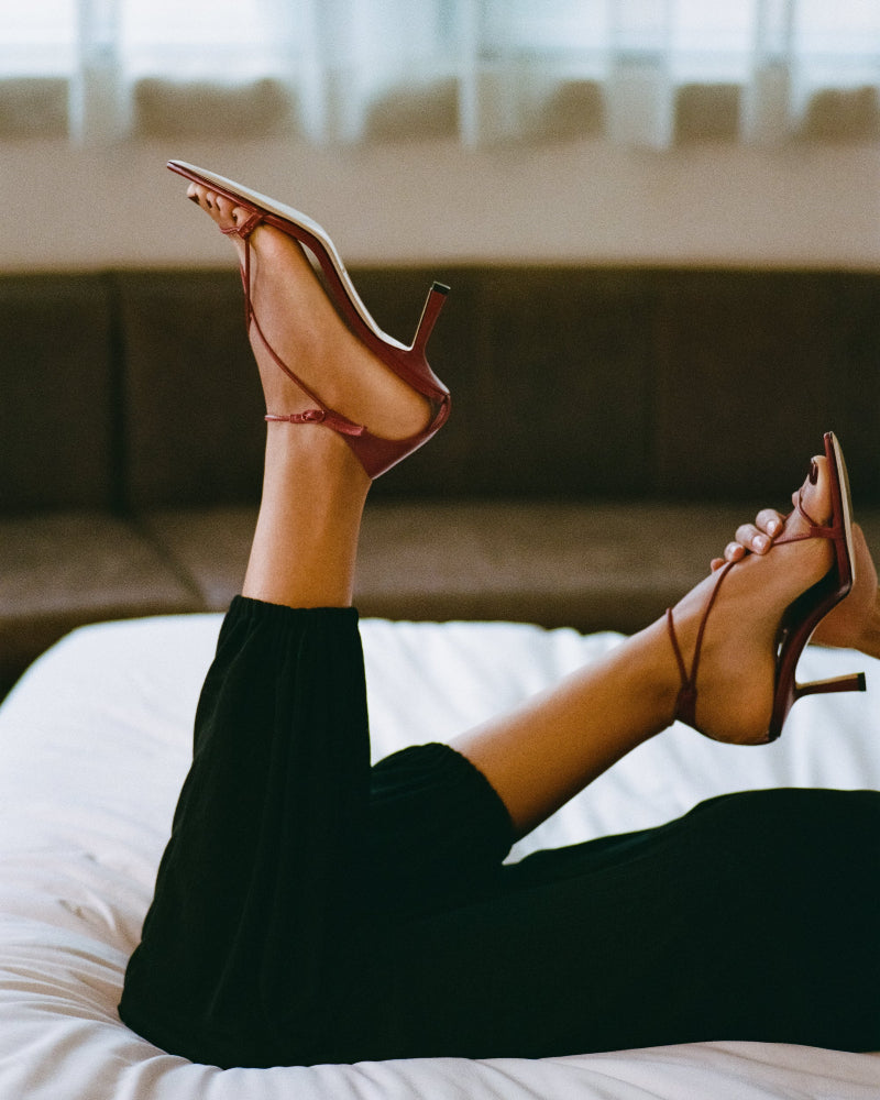 A pair of wine coloured high heels and black pants