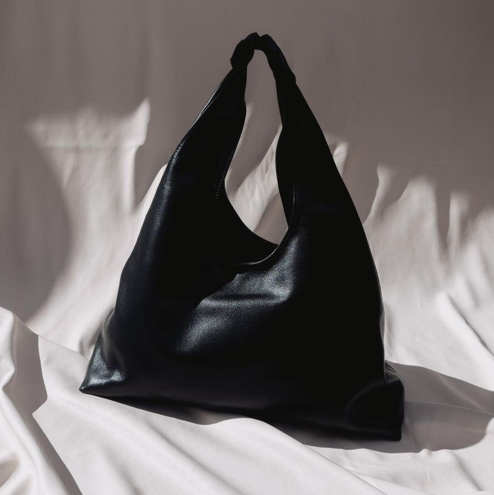 A black leather shoulder bag for women by Studio Amelia