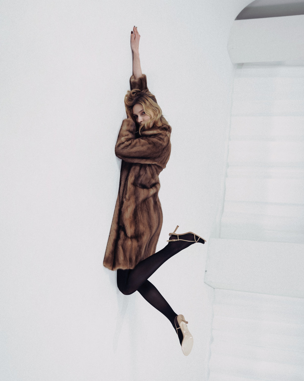 A woman wearing beige leather sandals with a high heel
