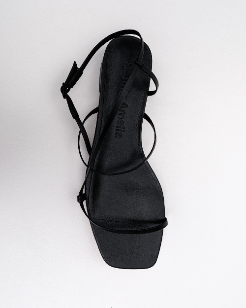 Black strappy sandals on a white background