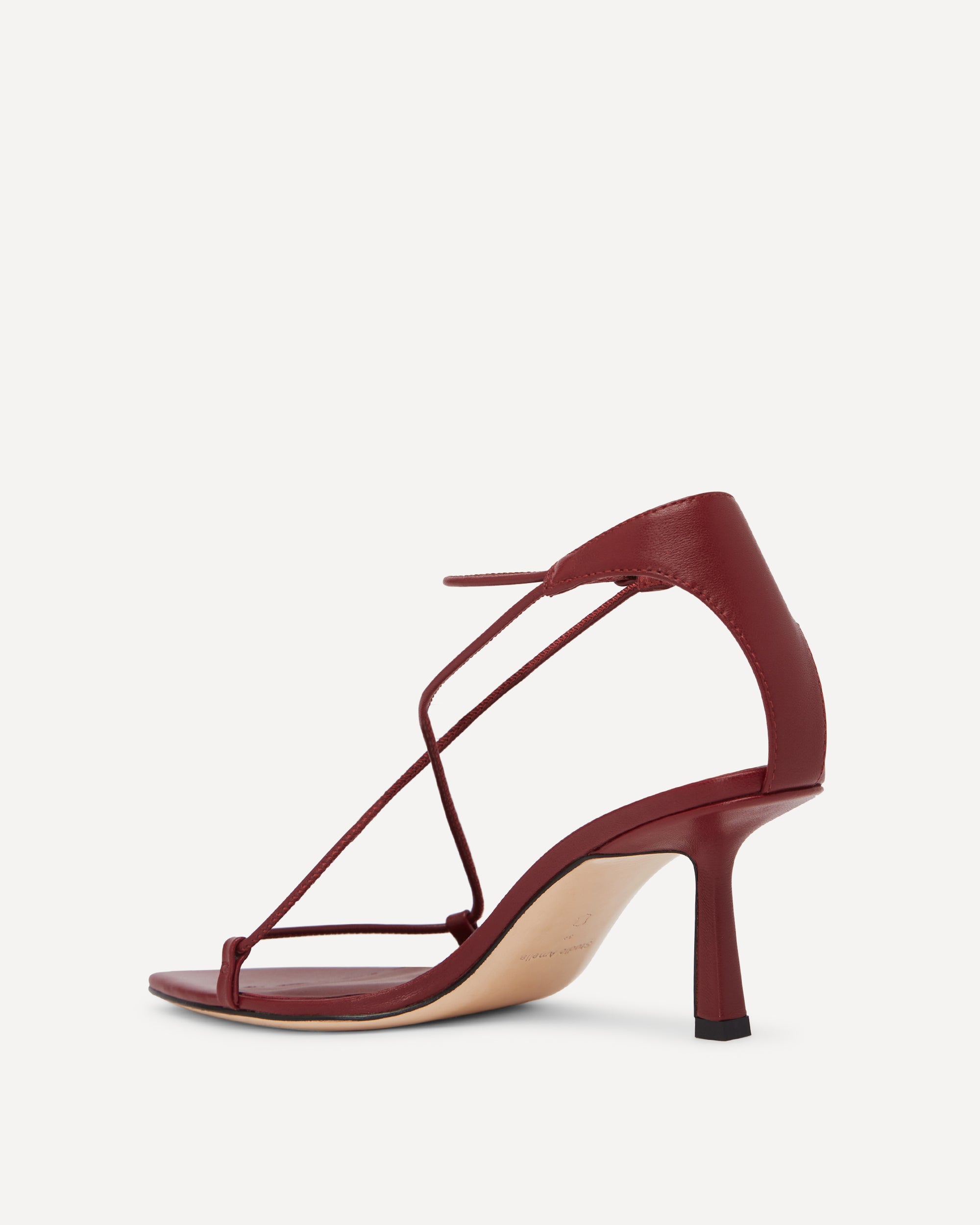 Maroon high-heeled sandal with thin straps on a white background